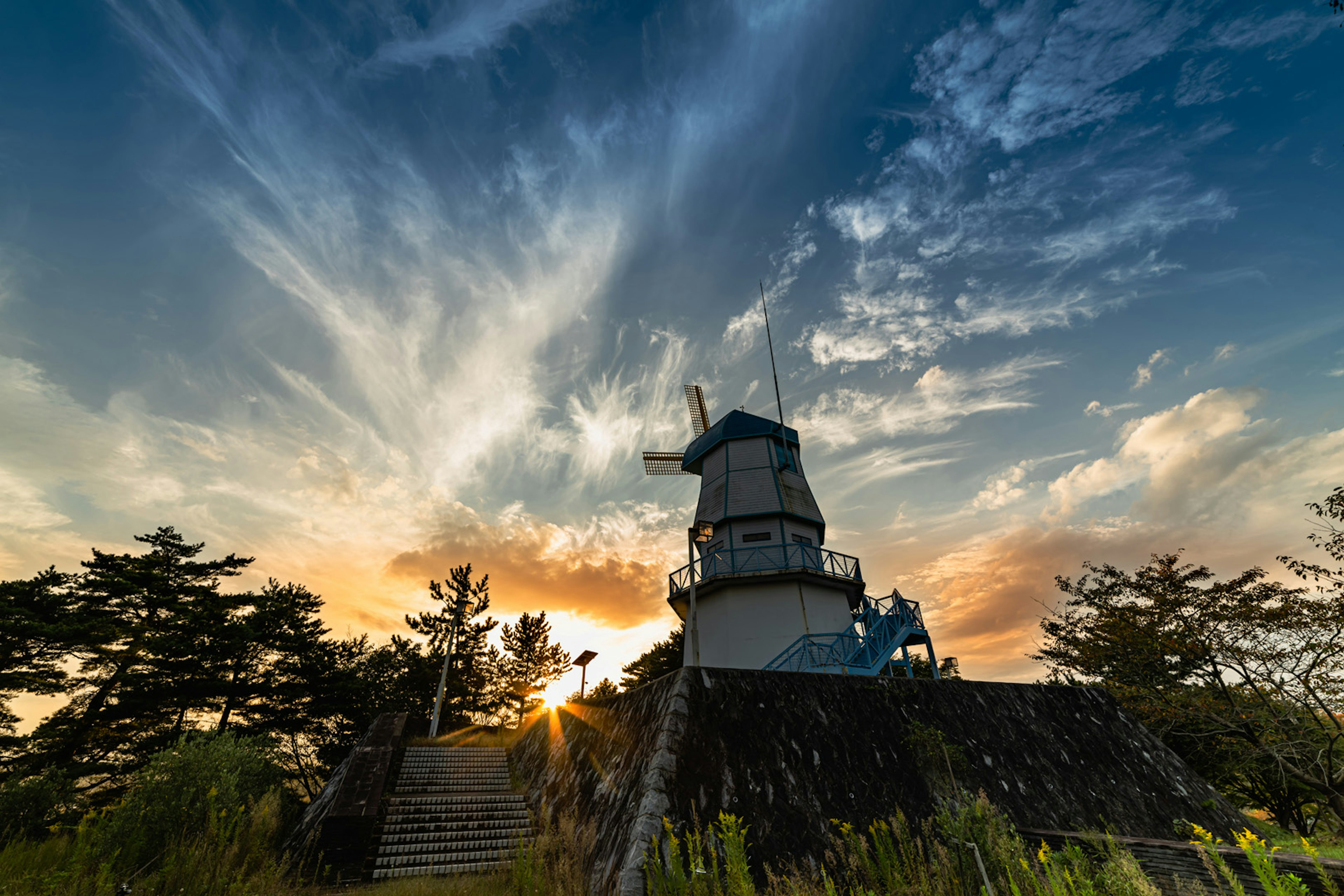 Silhouette eines Aussichtsturms vor einem Sonnenuntergang und schönen Wolken