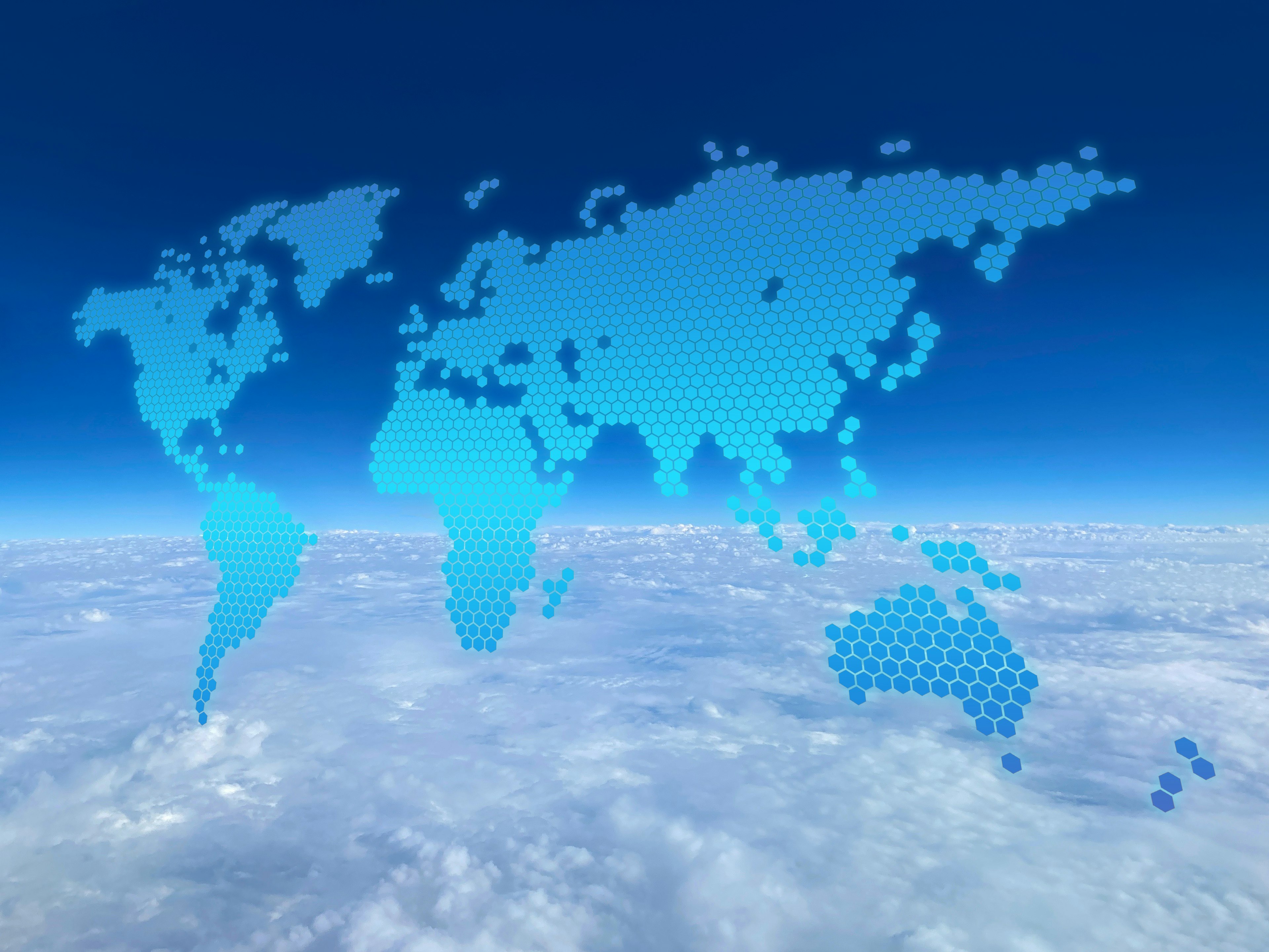 Hexagonal world map floating in blue sky