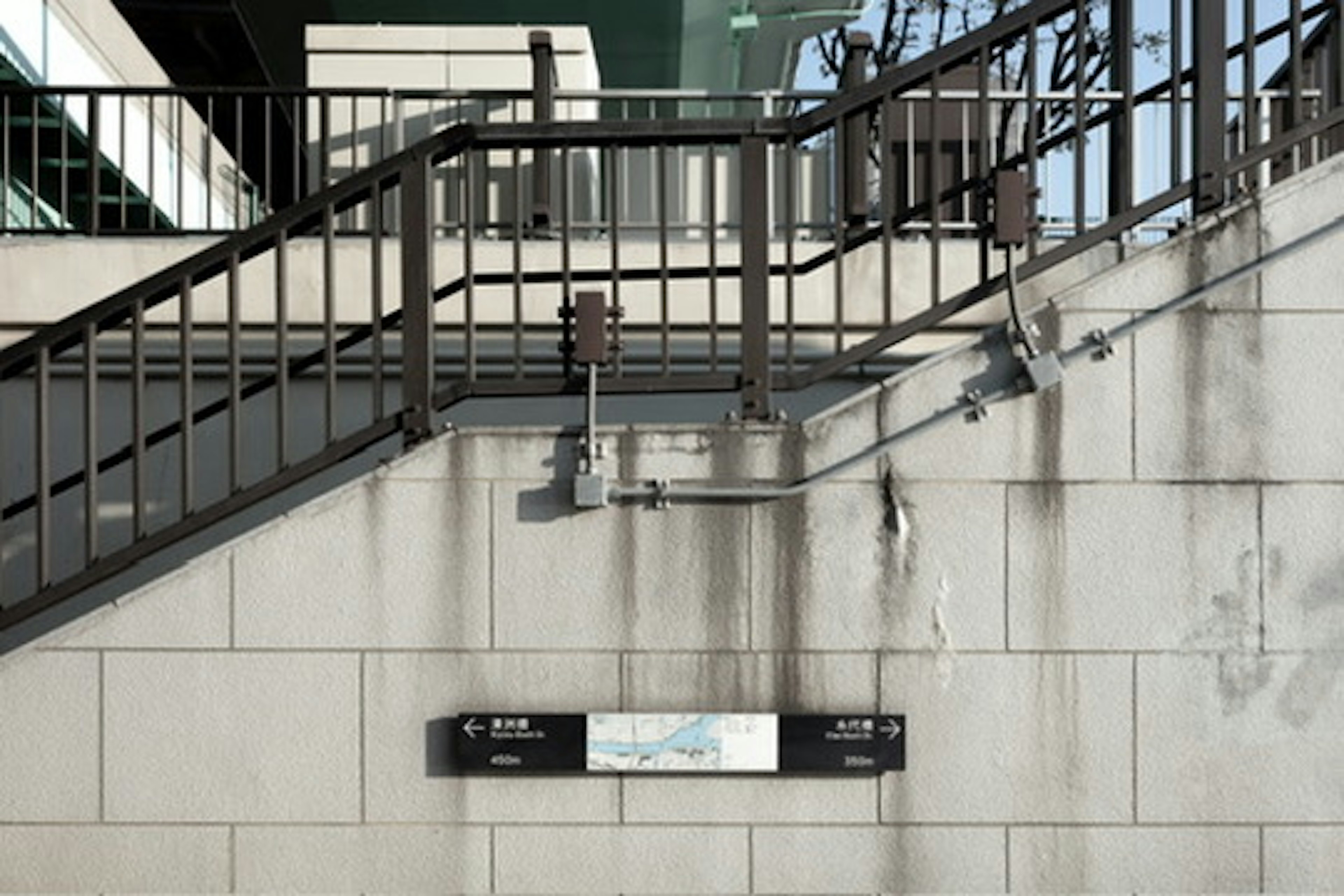 Vista de la estación con barandillas de escaleras y pared sucia