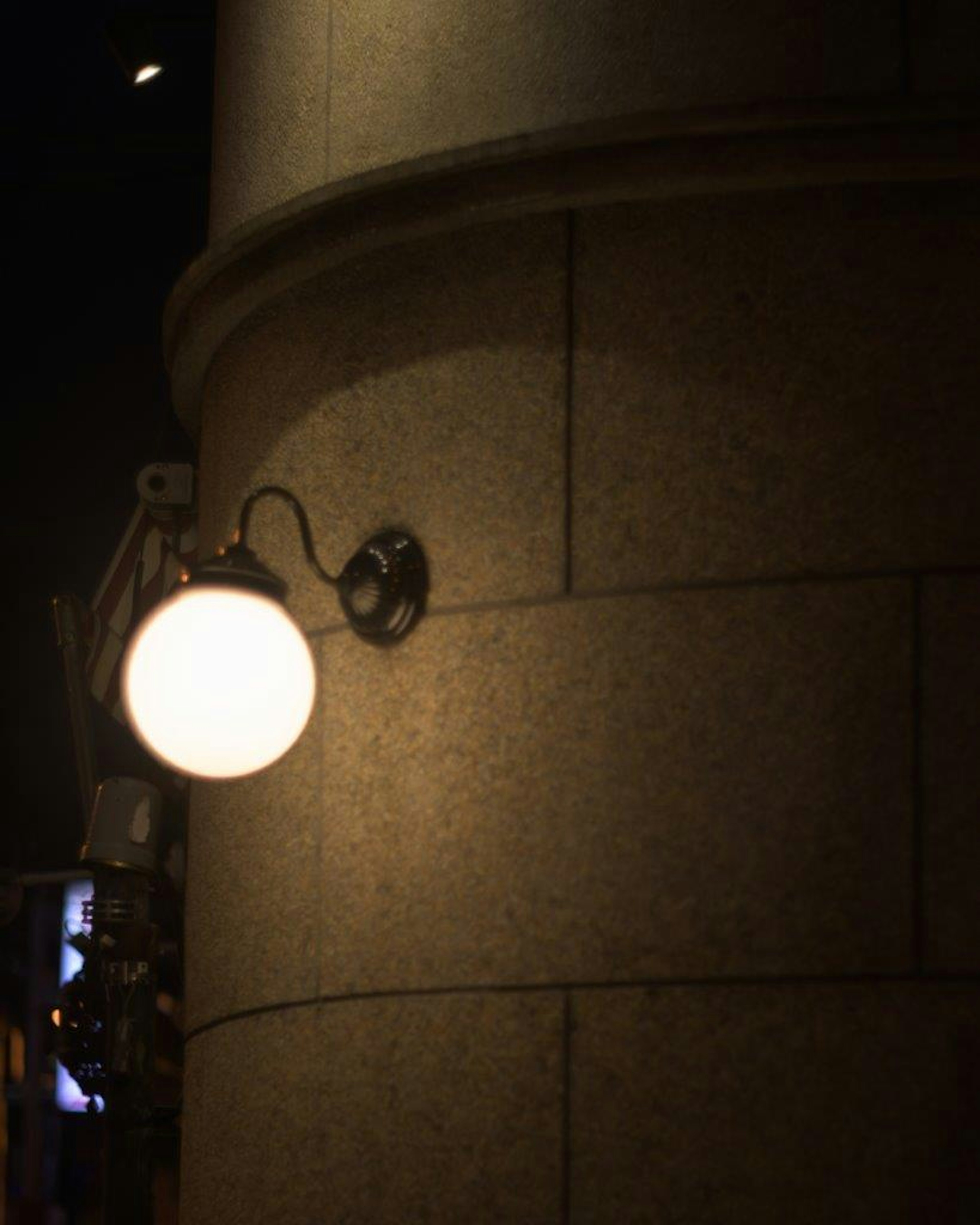 Una farola montada en una columna de piedra por la noche