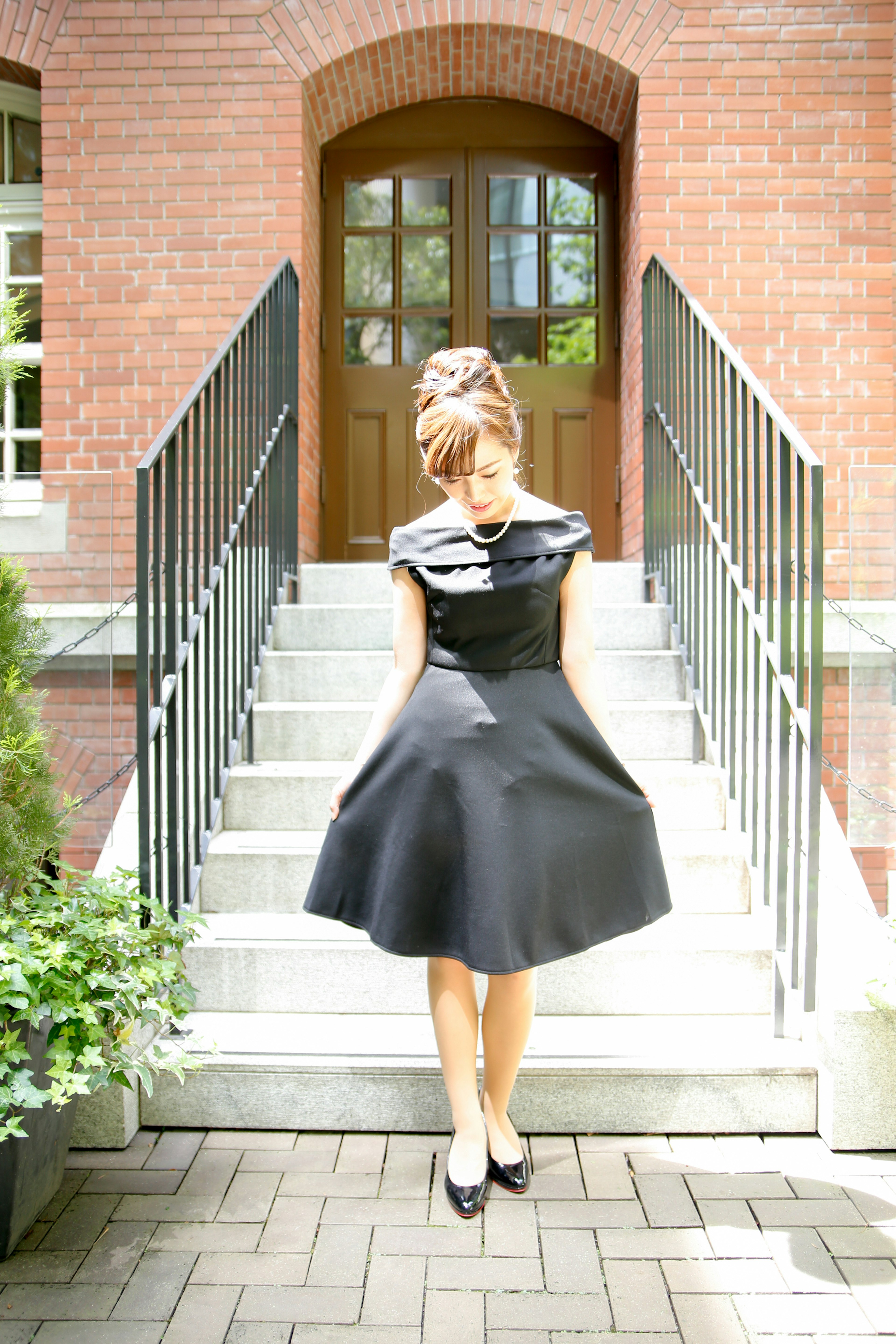 Mujer con vestido negro de pie en la parte superior de las escaleras