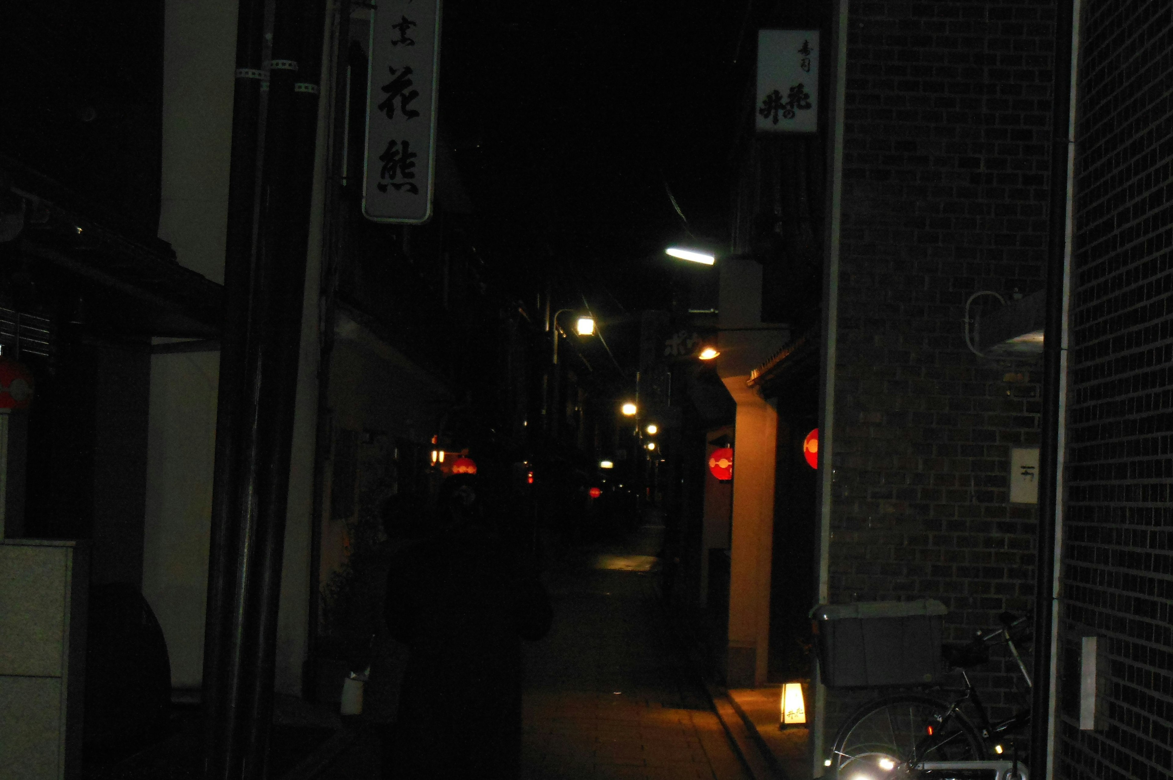 Calle tranquila por la noche iluminada por luces y letreros