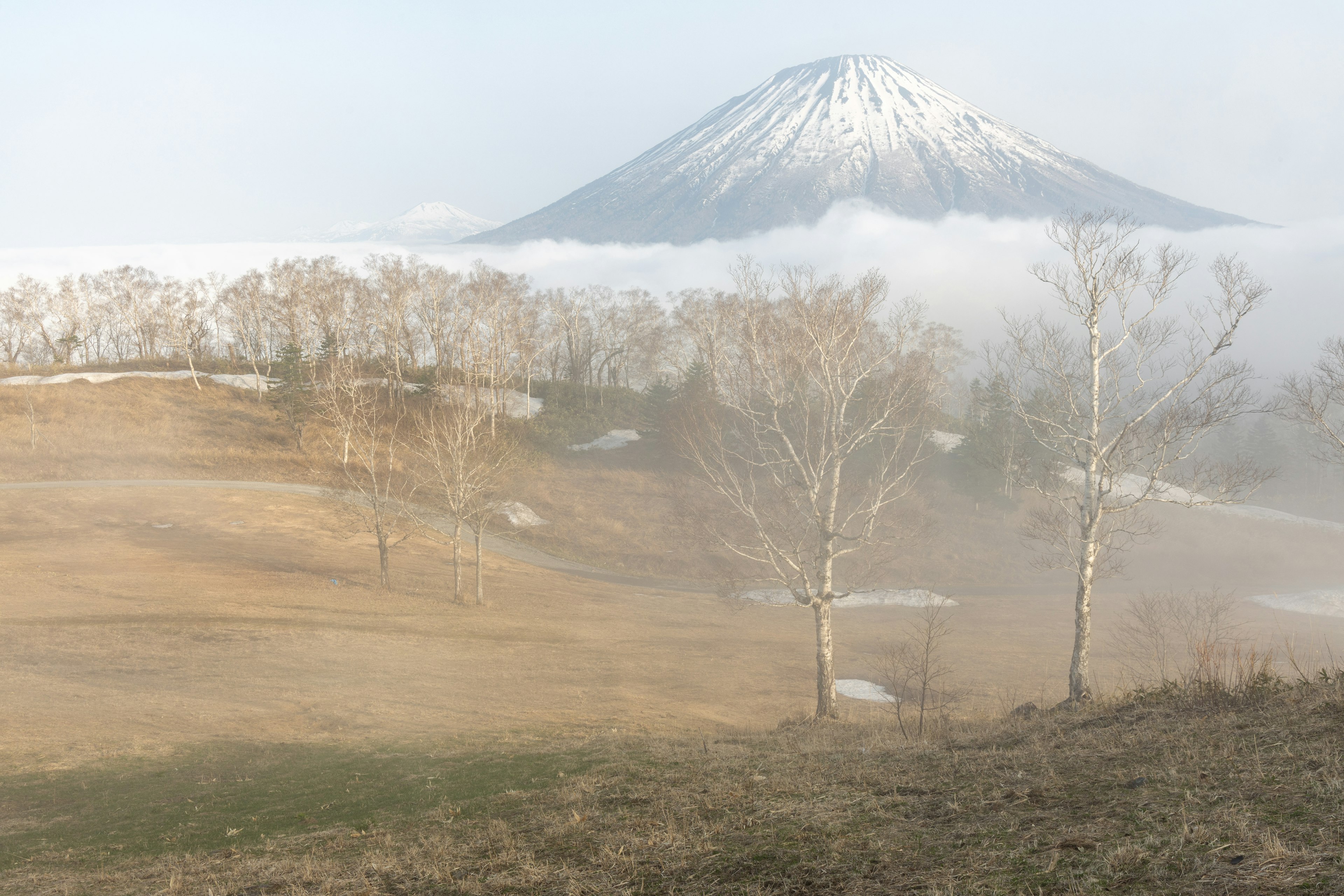 Snow-capped mountain surrounded by mist and a serene landscape