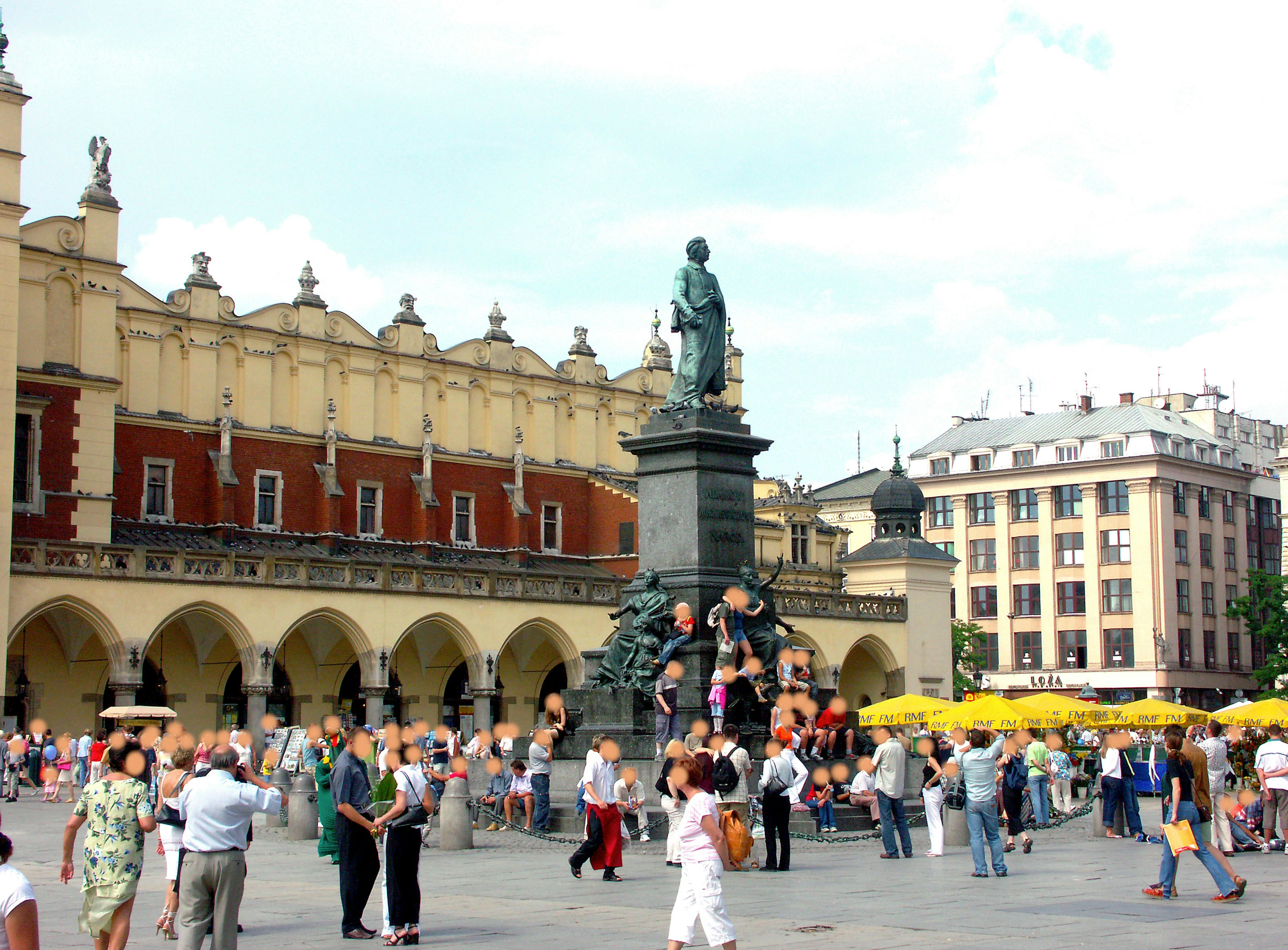 Multitud de personas en la plaza principal de Cracovia con edificios históricos