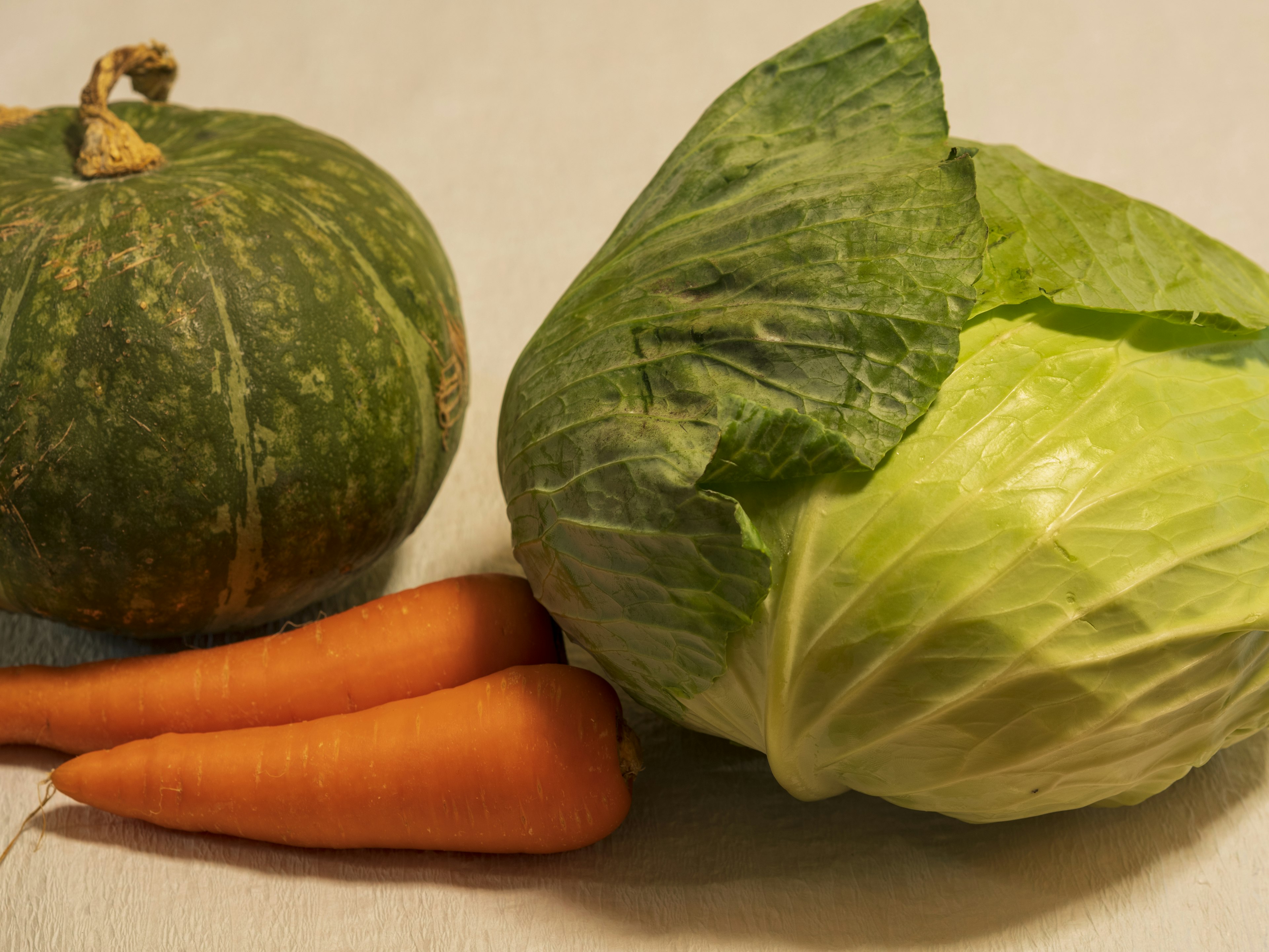 Imagen de una calabaza repollo y zanahorias dispuestas juntas