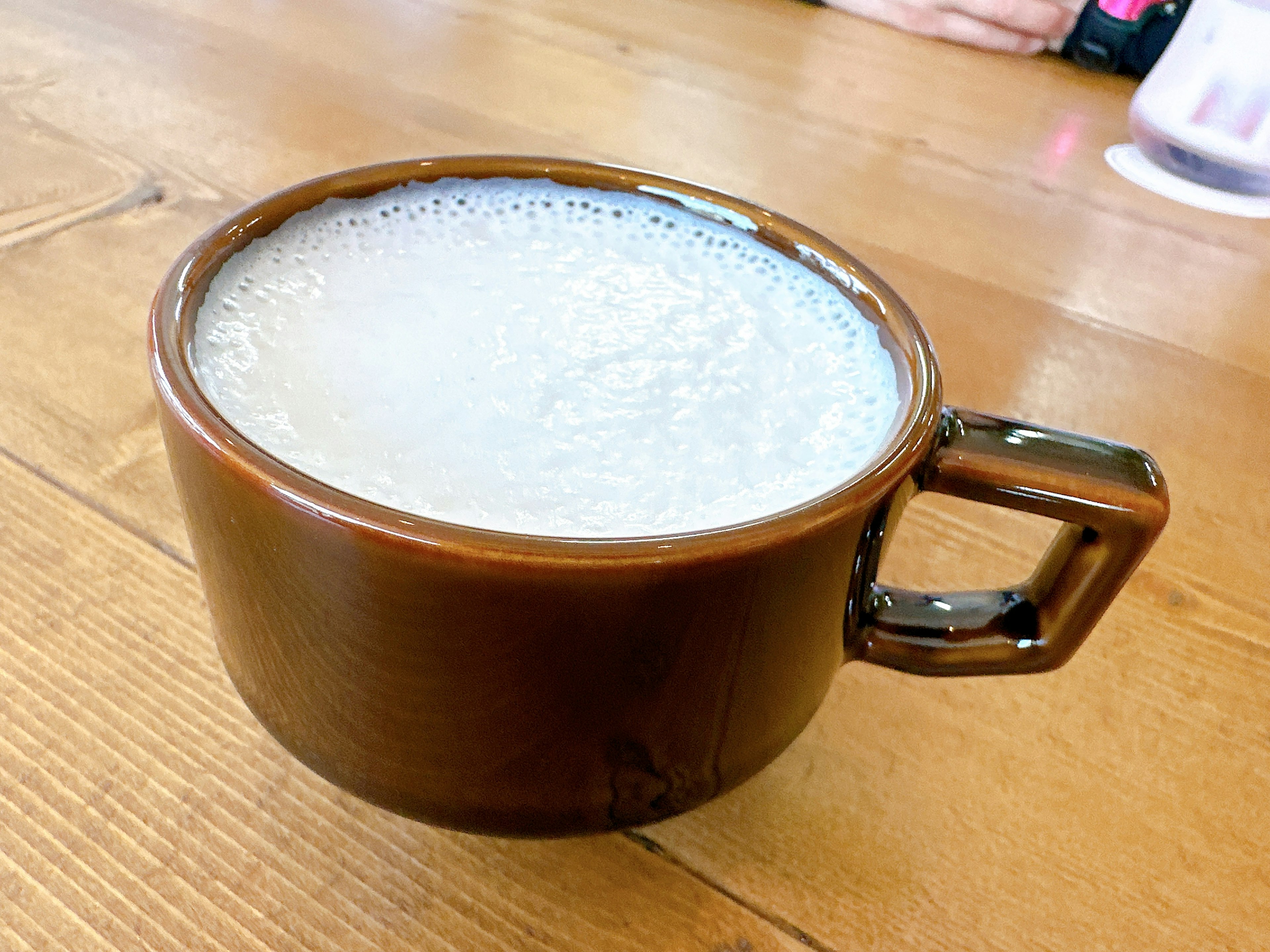 Une boisson mousseuse dans une tasse marron