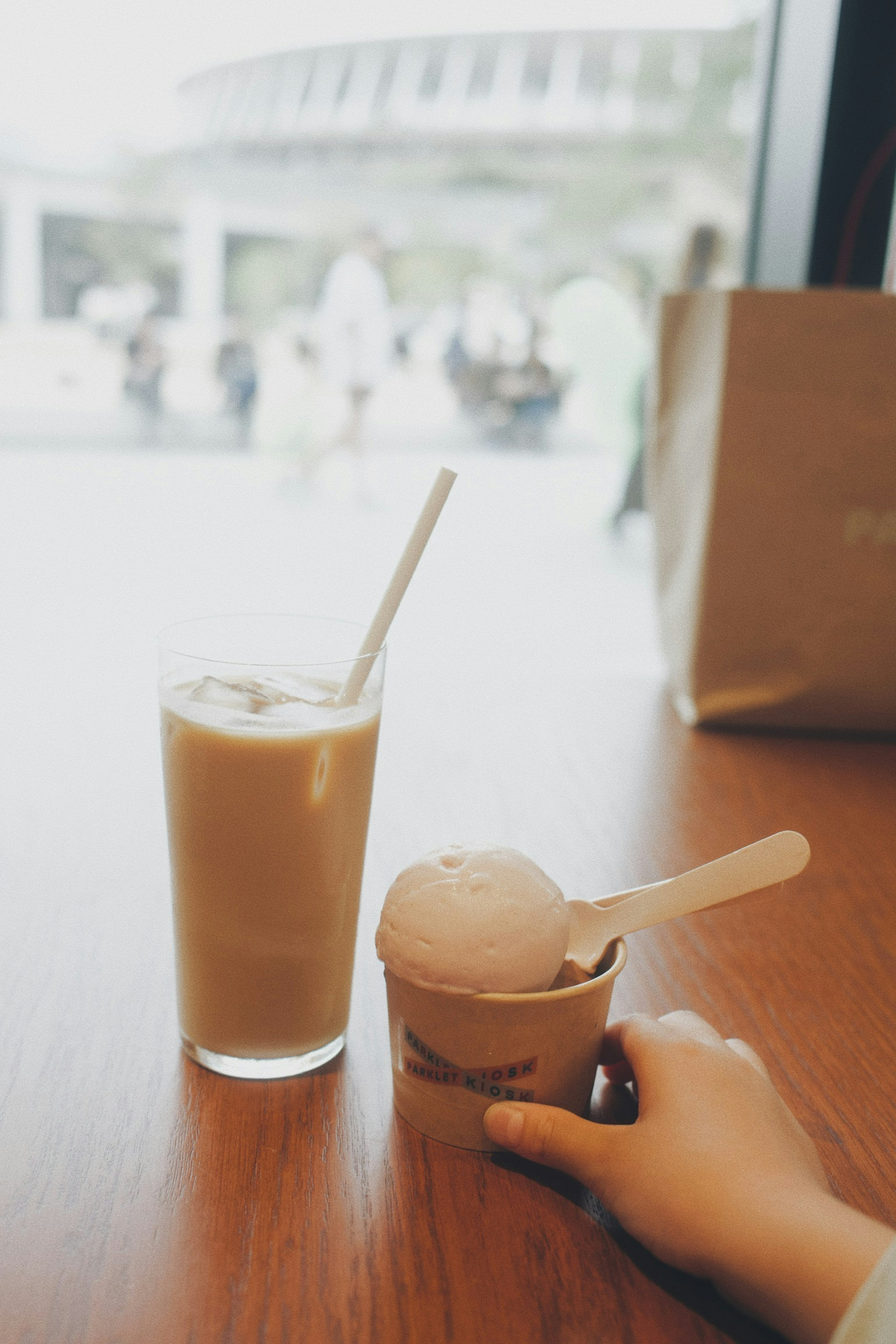 Ice cream and a beverage on a café table with a blurred background