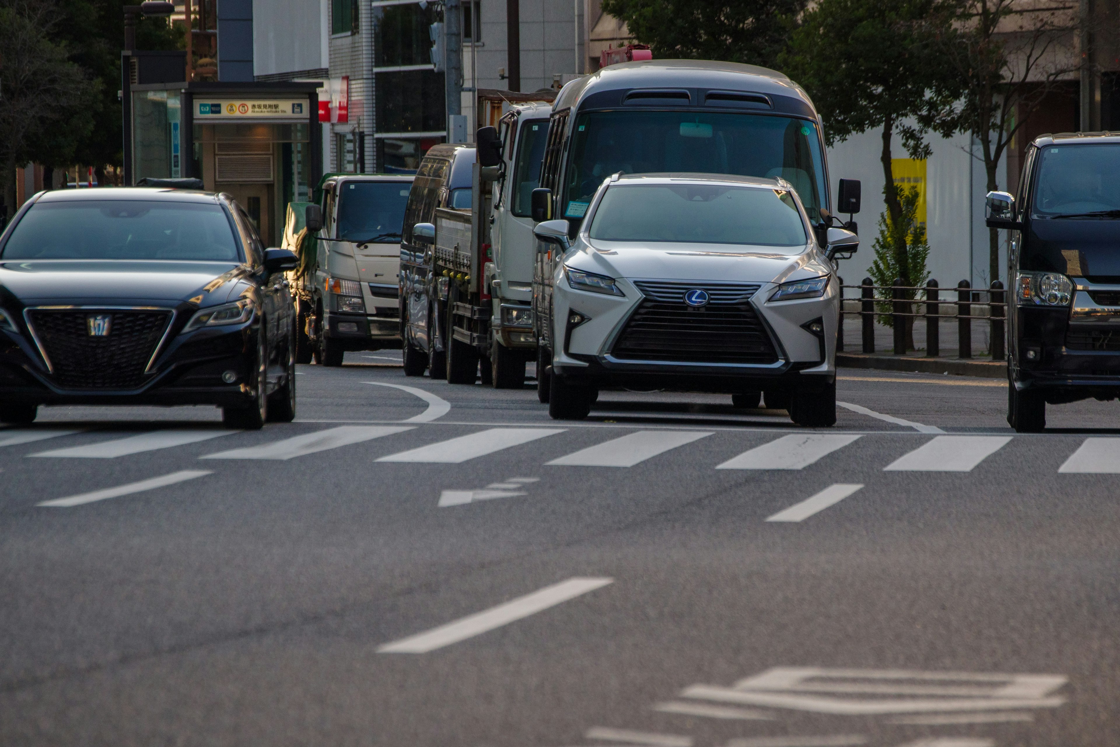 都市の道路で走行中の車両群と横断歩道