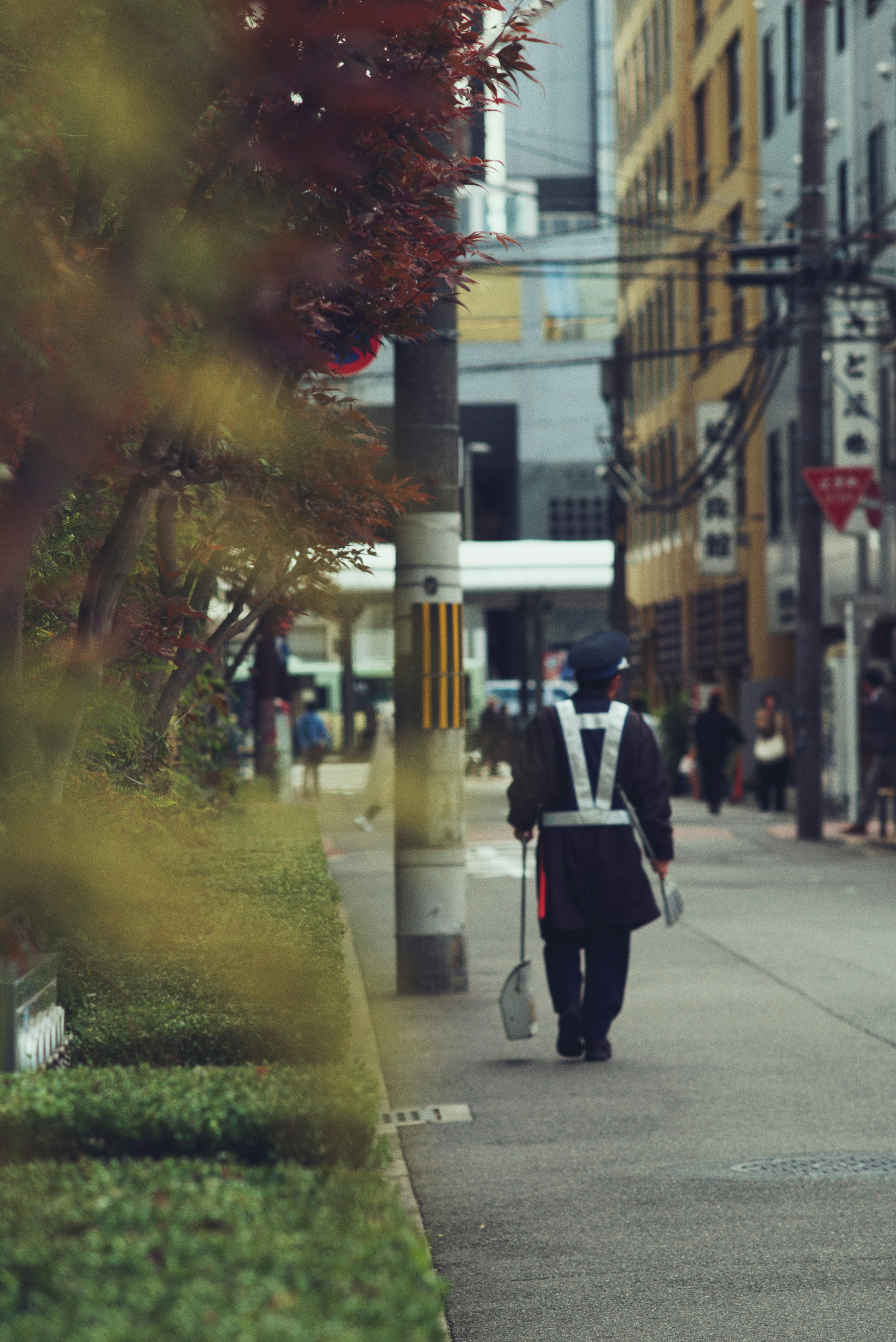 A security guard walking down a city street with surrounding buildings