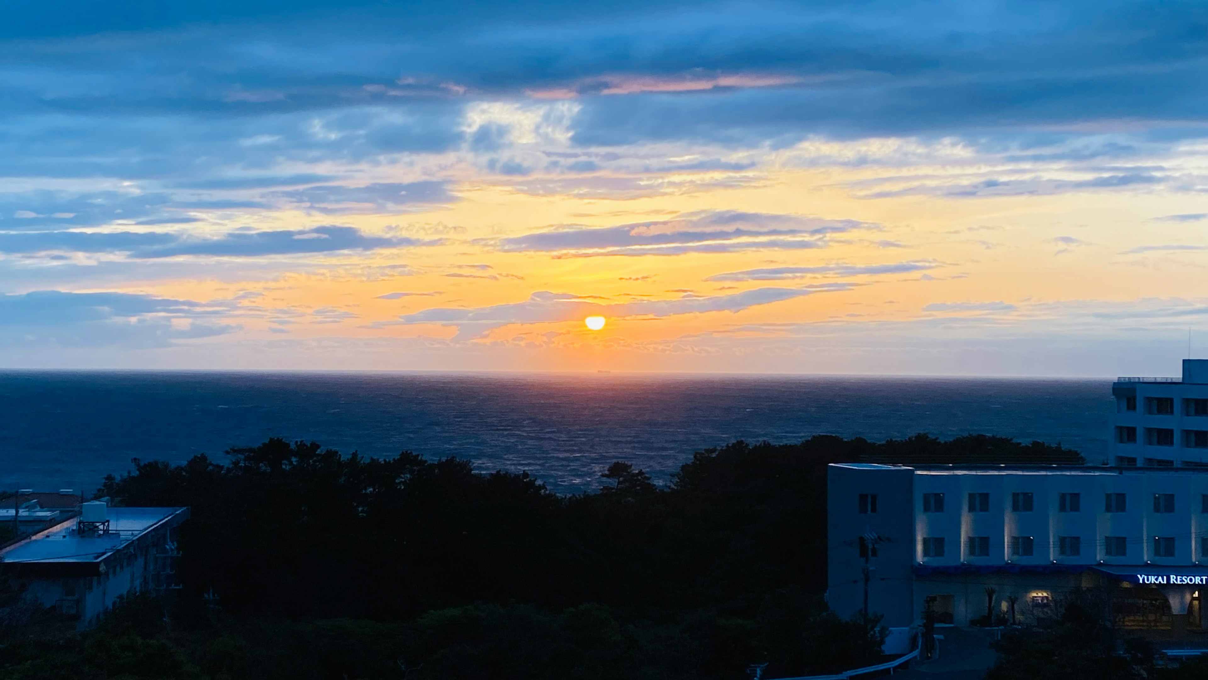 海と空の間に沈む夕日が見える美しい風景