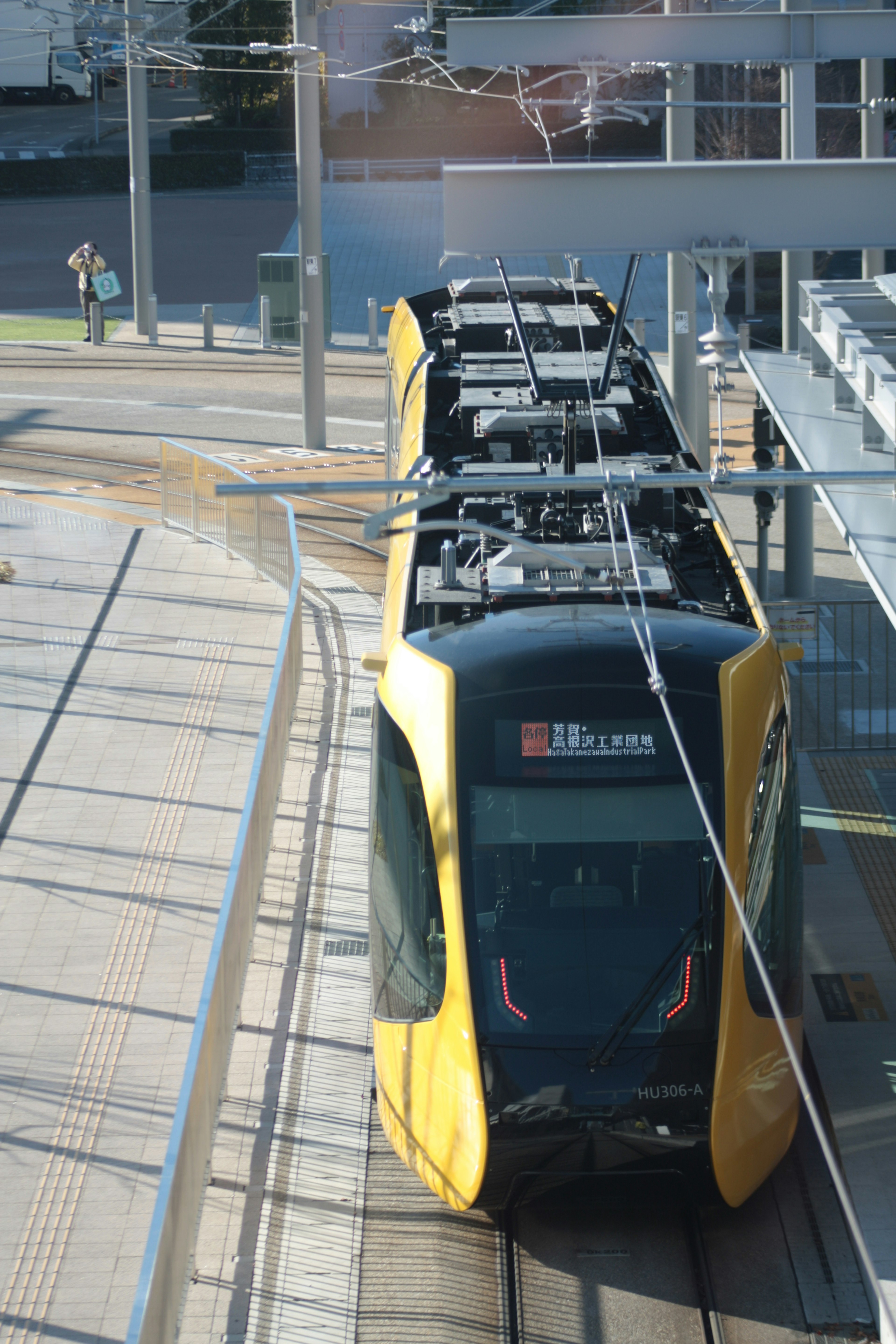 Tram kuning diparkir di stasiun modern