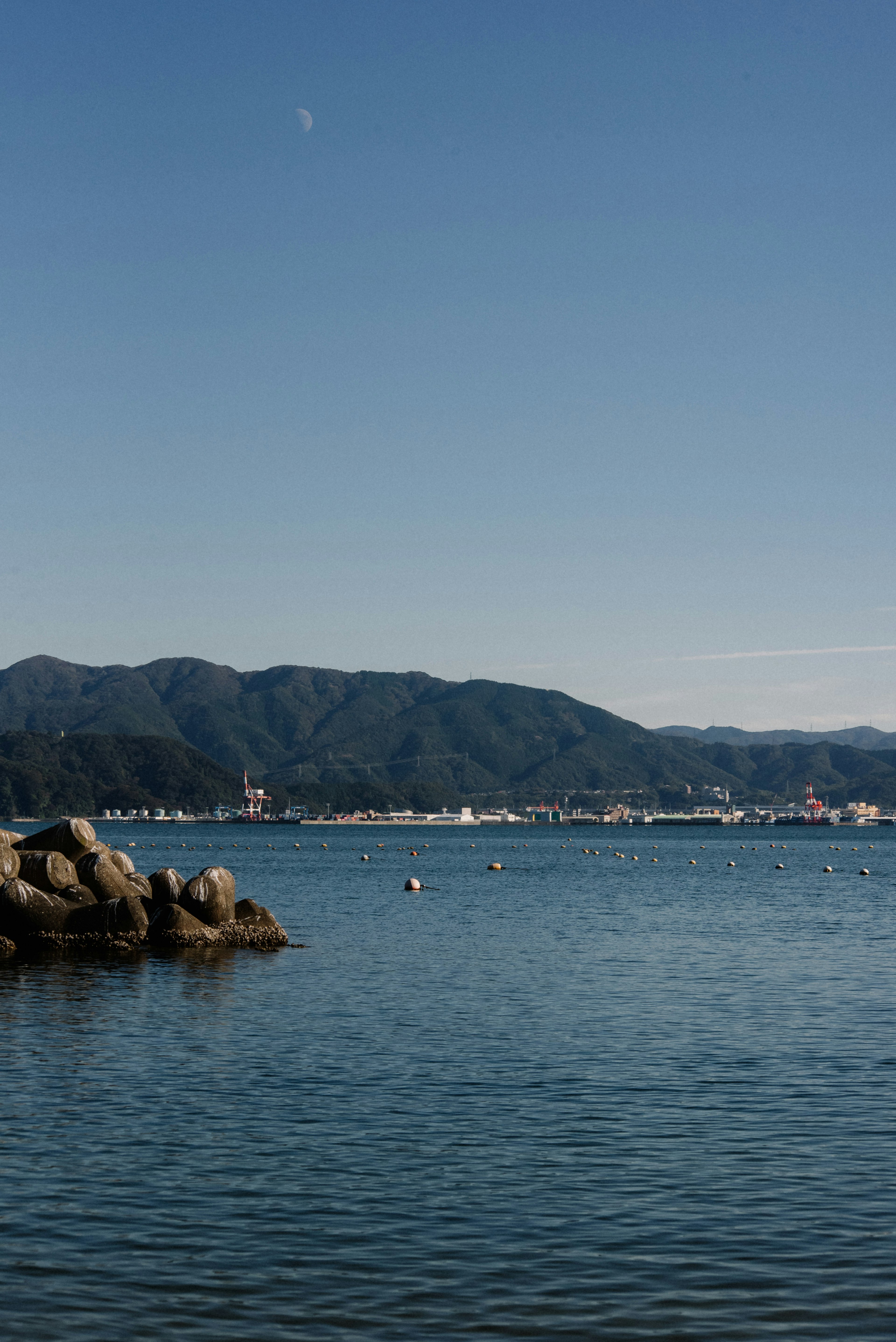 藍色海洋和山脈的風景，岩石和寧靜的水面