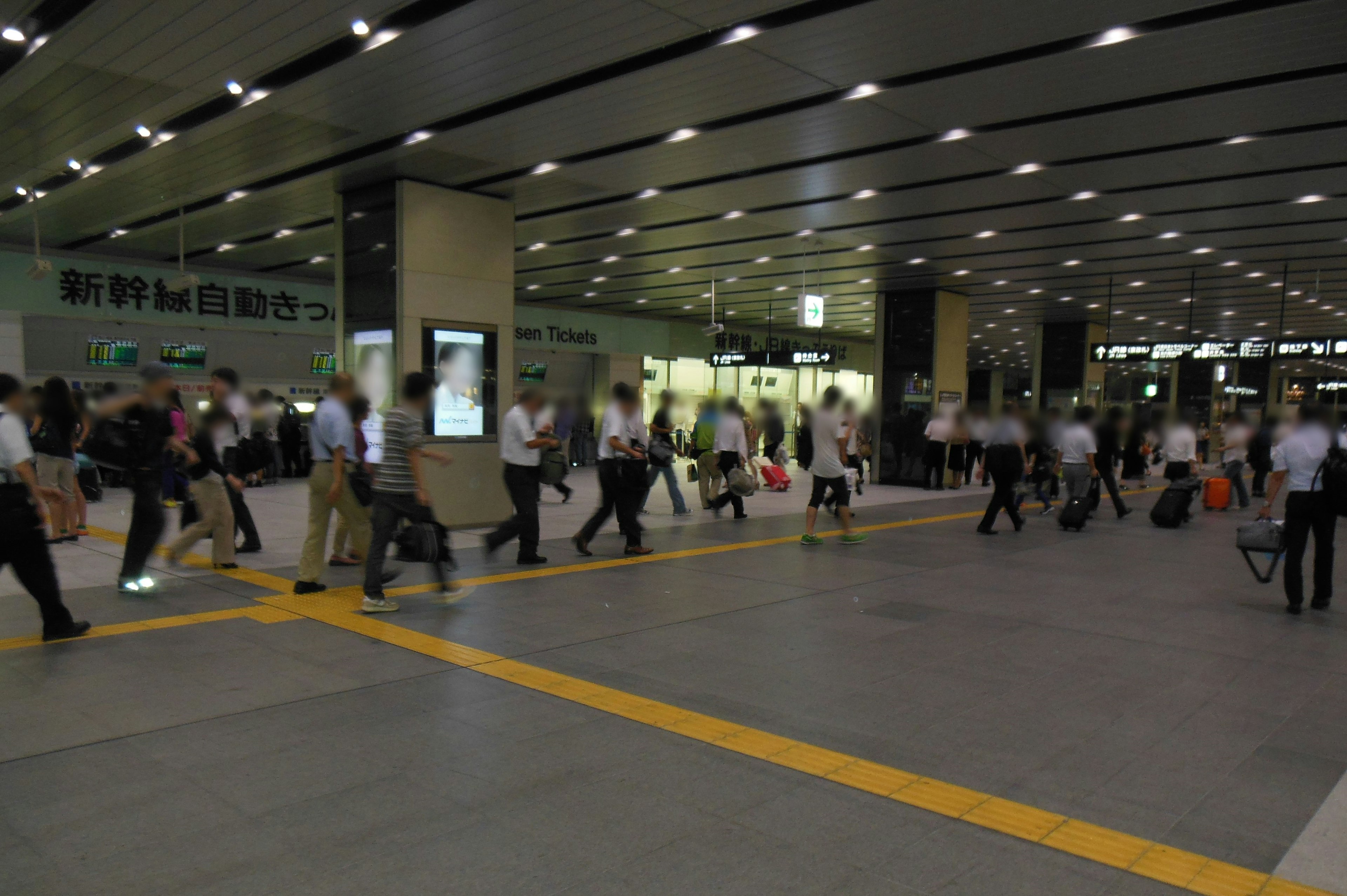 駅の混雑した通路に人々が行き交う様子