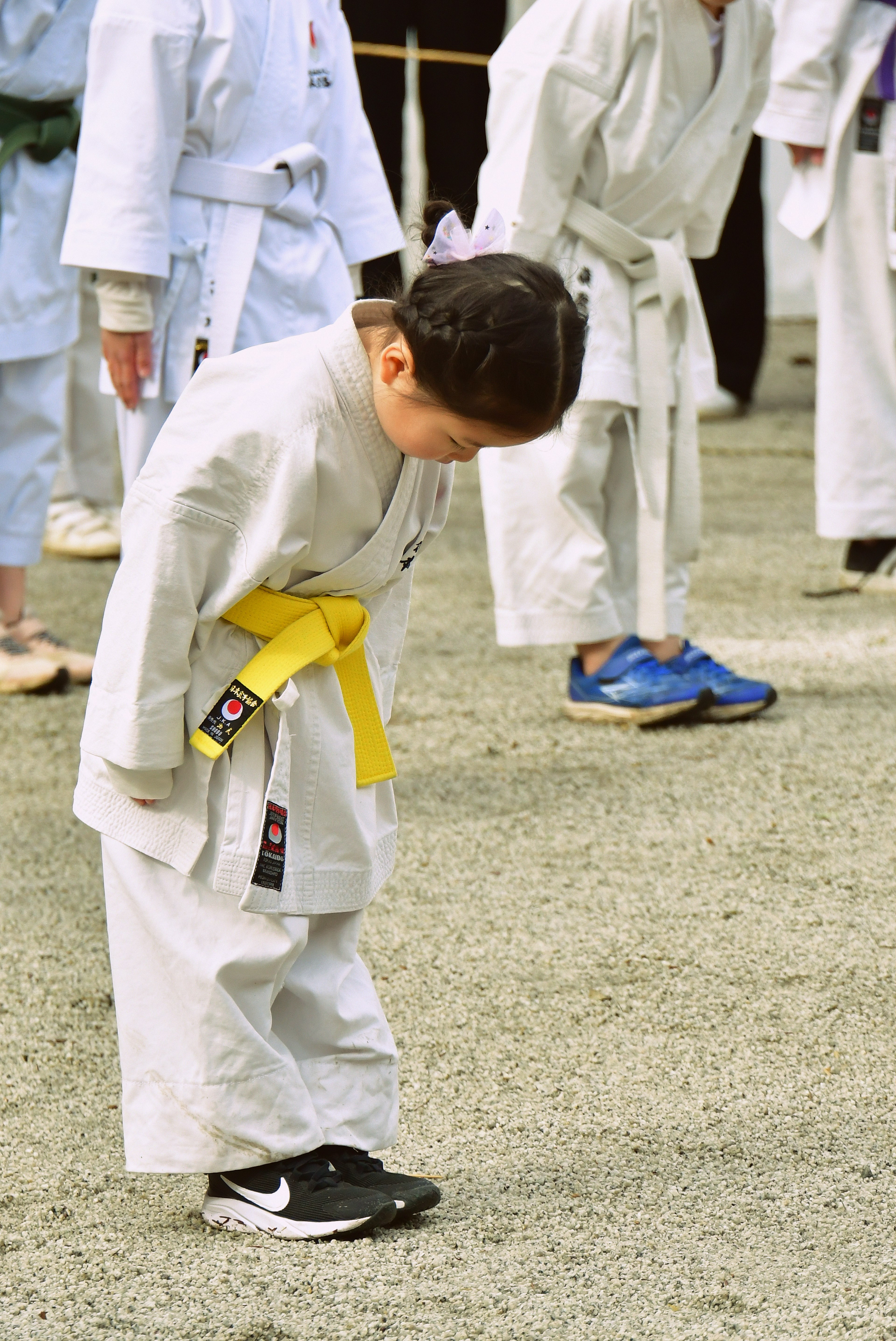 Niño inclinándose durante la práctica de karate con un cinturón amarillo