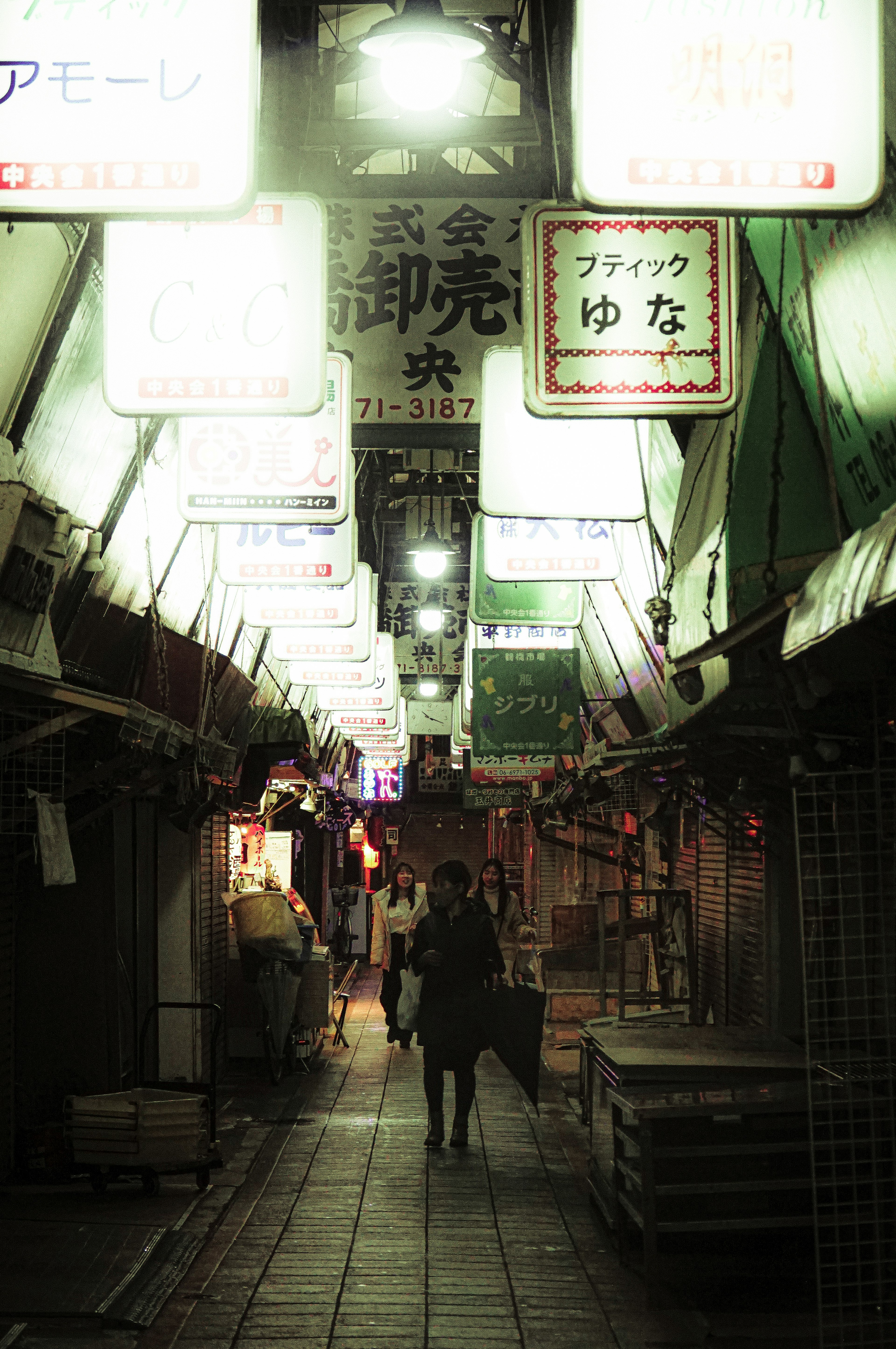 Dimly lit street with lanterns and signs in a shopping district