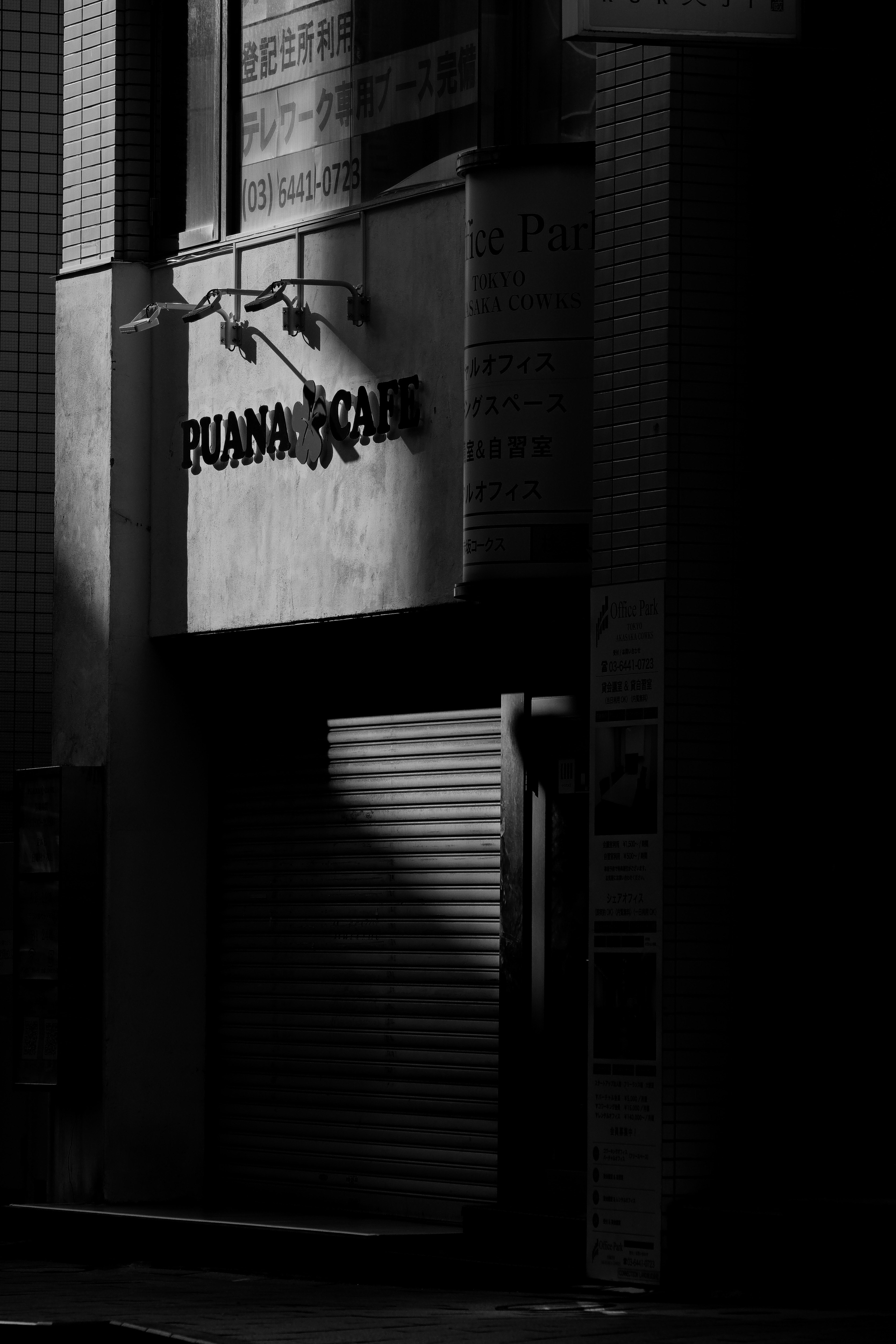 Exterior of a shuttered storefront on a dark street