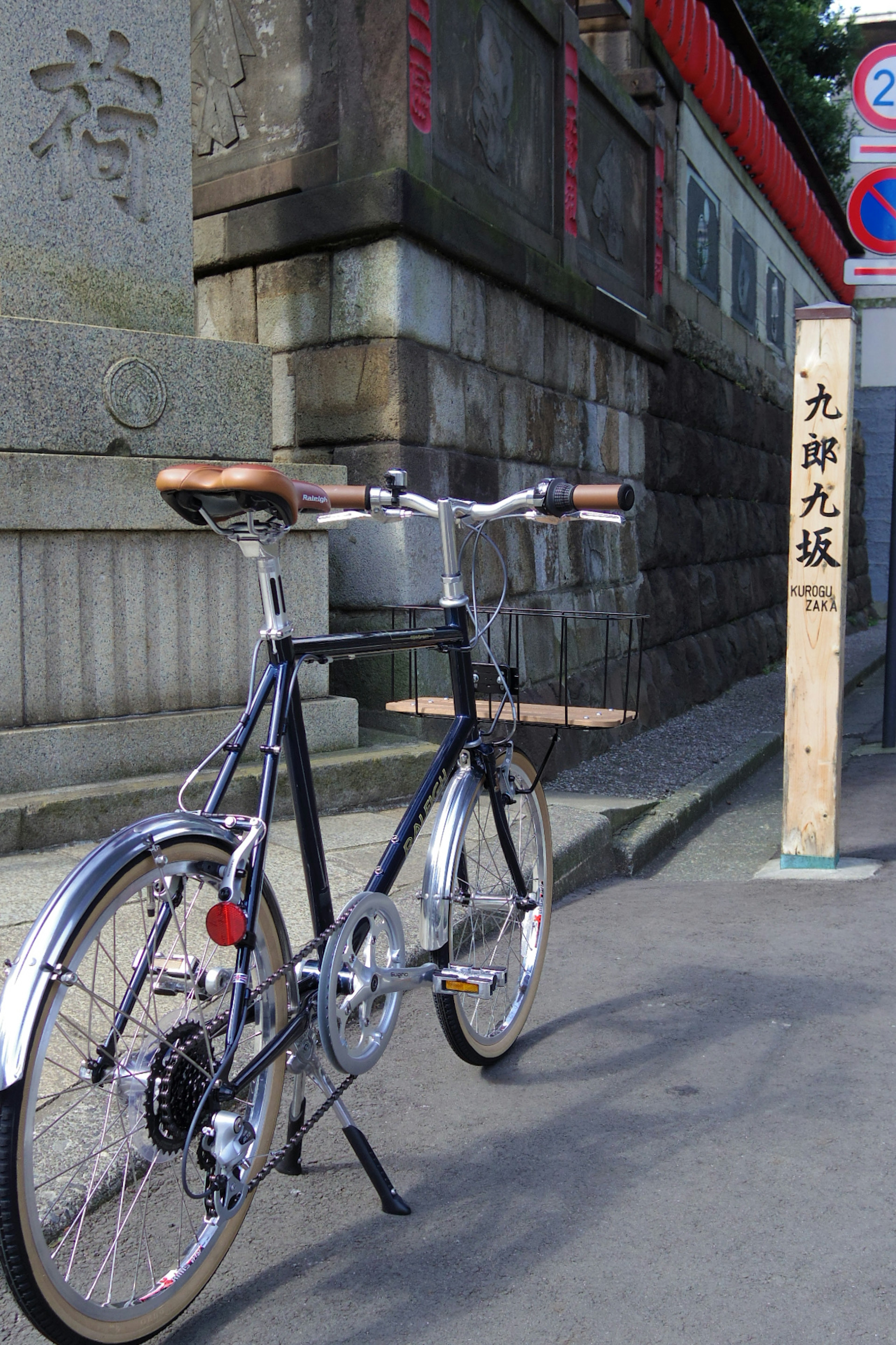 Una bicicleta estacionada en la calle con un fondo de piedra