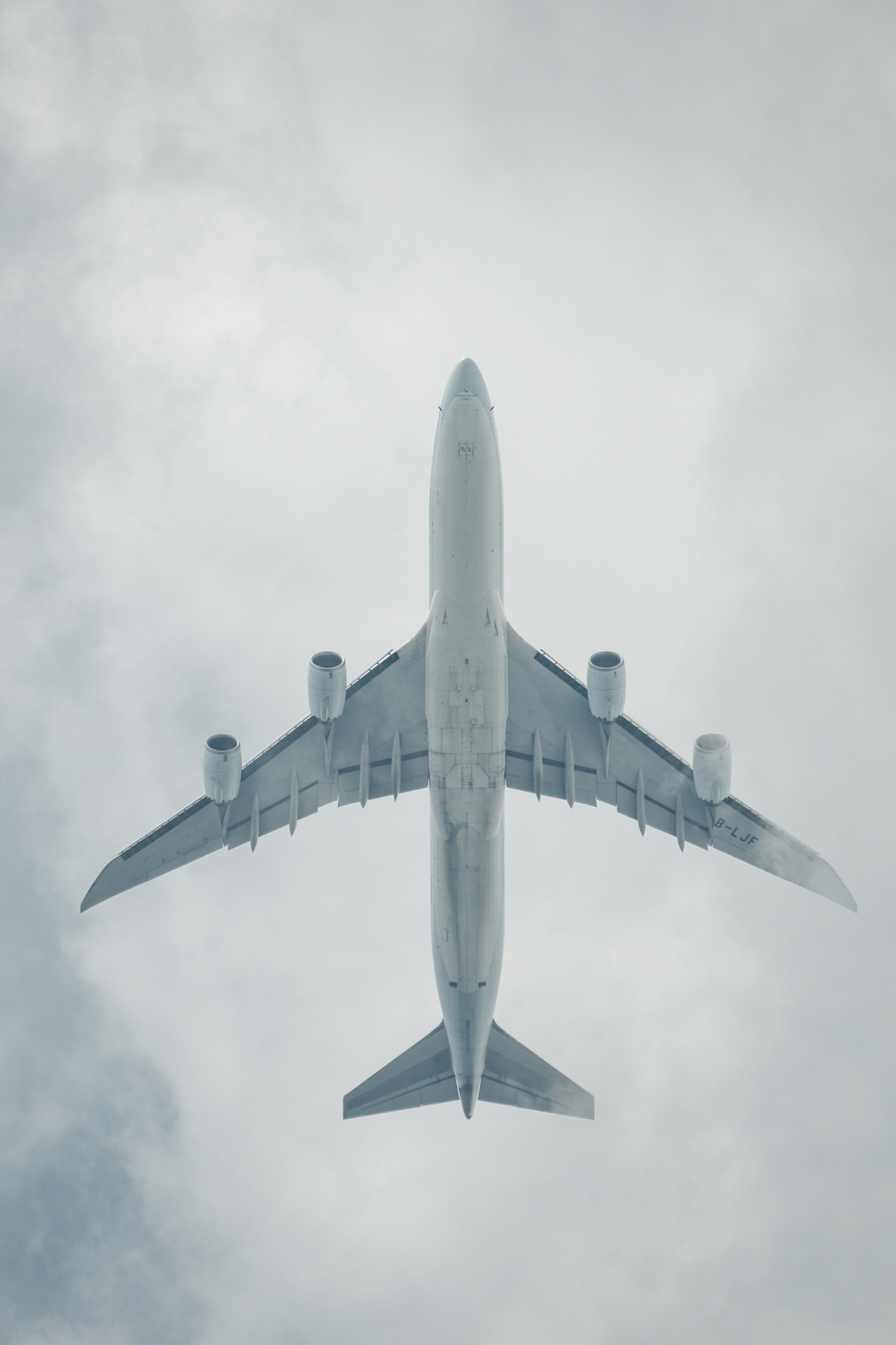 Airplane flying above the clouds viewed from below