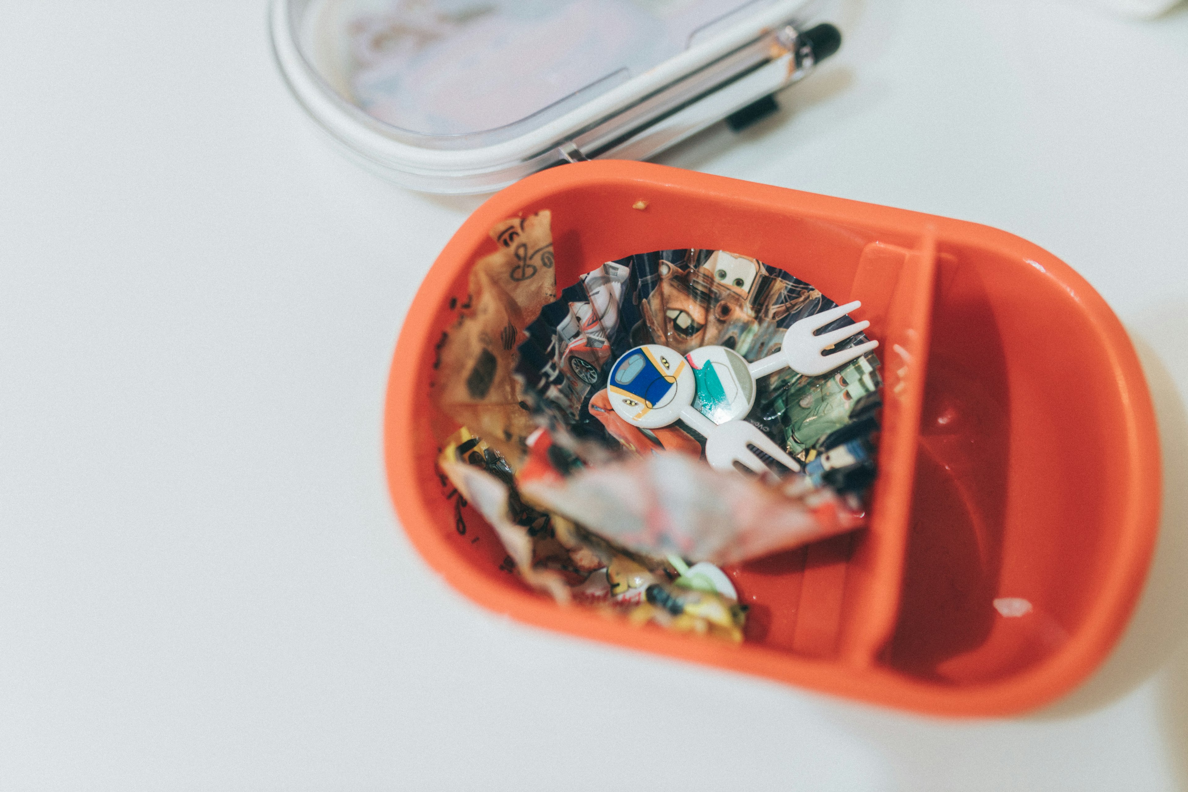 Red lunchbox containing colorful food and a white fork