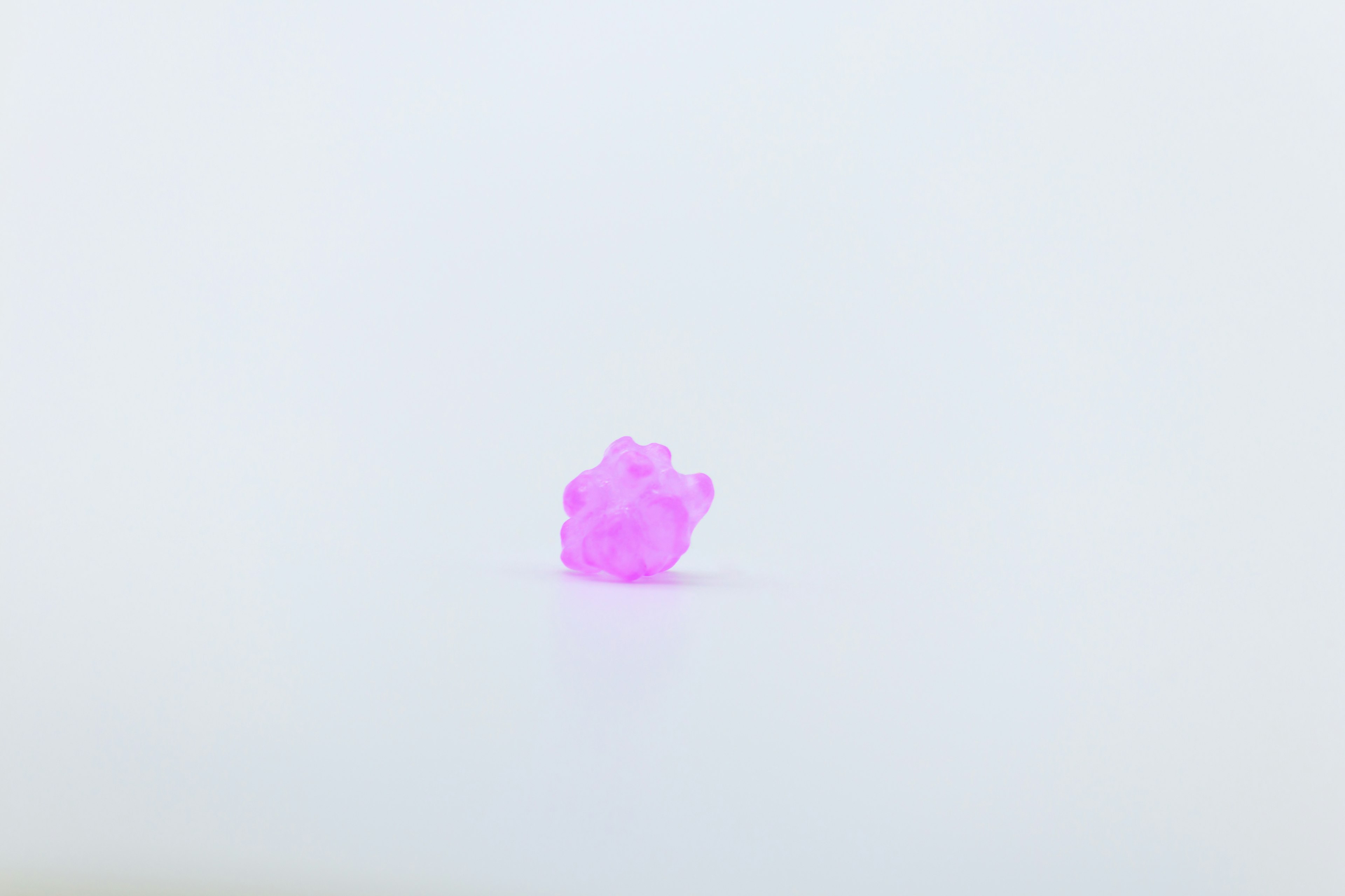 Small pink crystal positioned on a white background