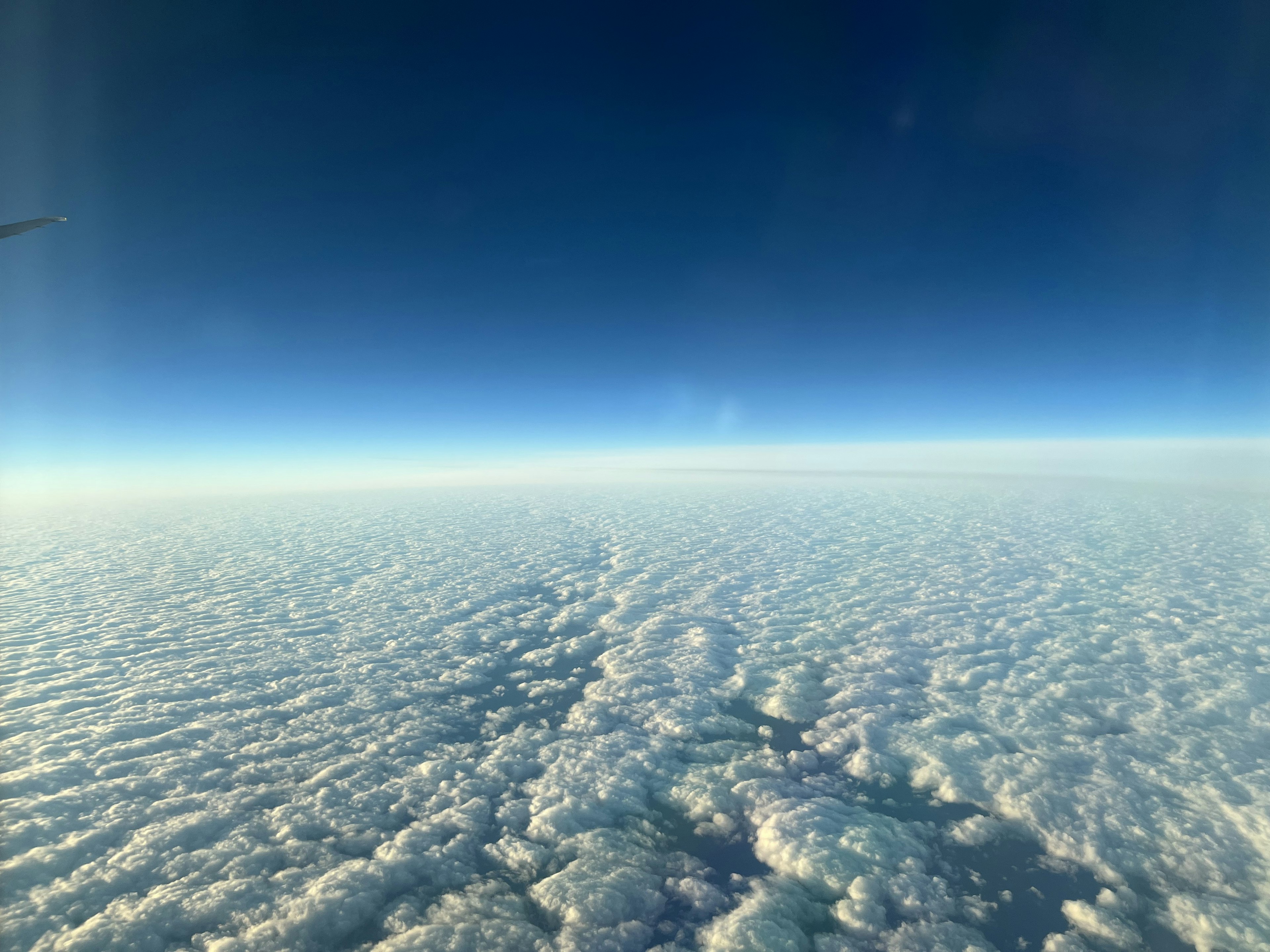 空の青と白い雲の広がりが見える航空写真