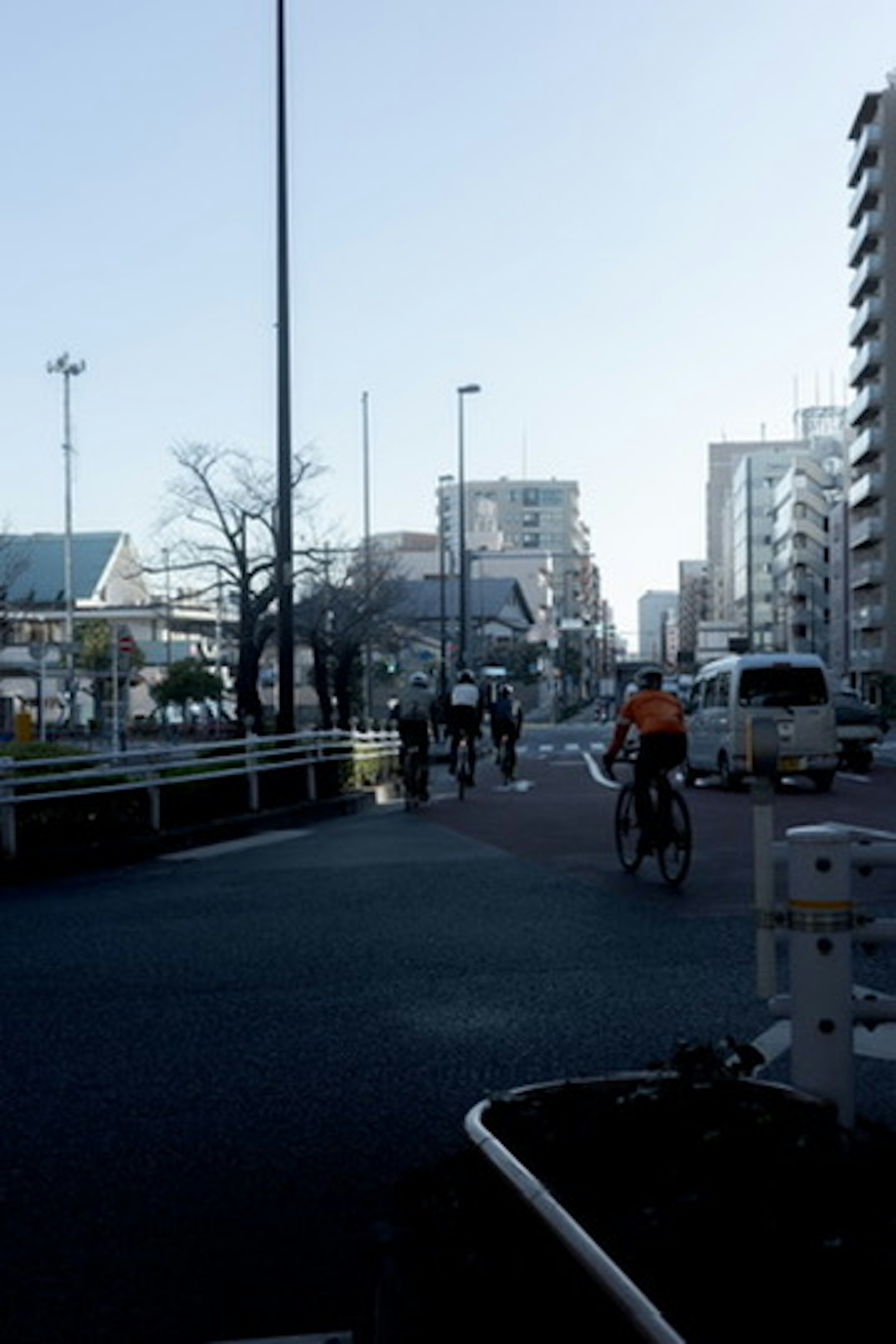 自転車をこぐ人々がいる都市の風景 高層ビルと青空