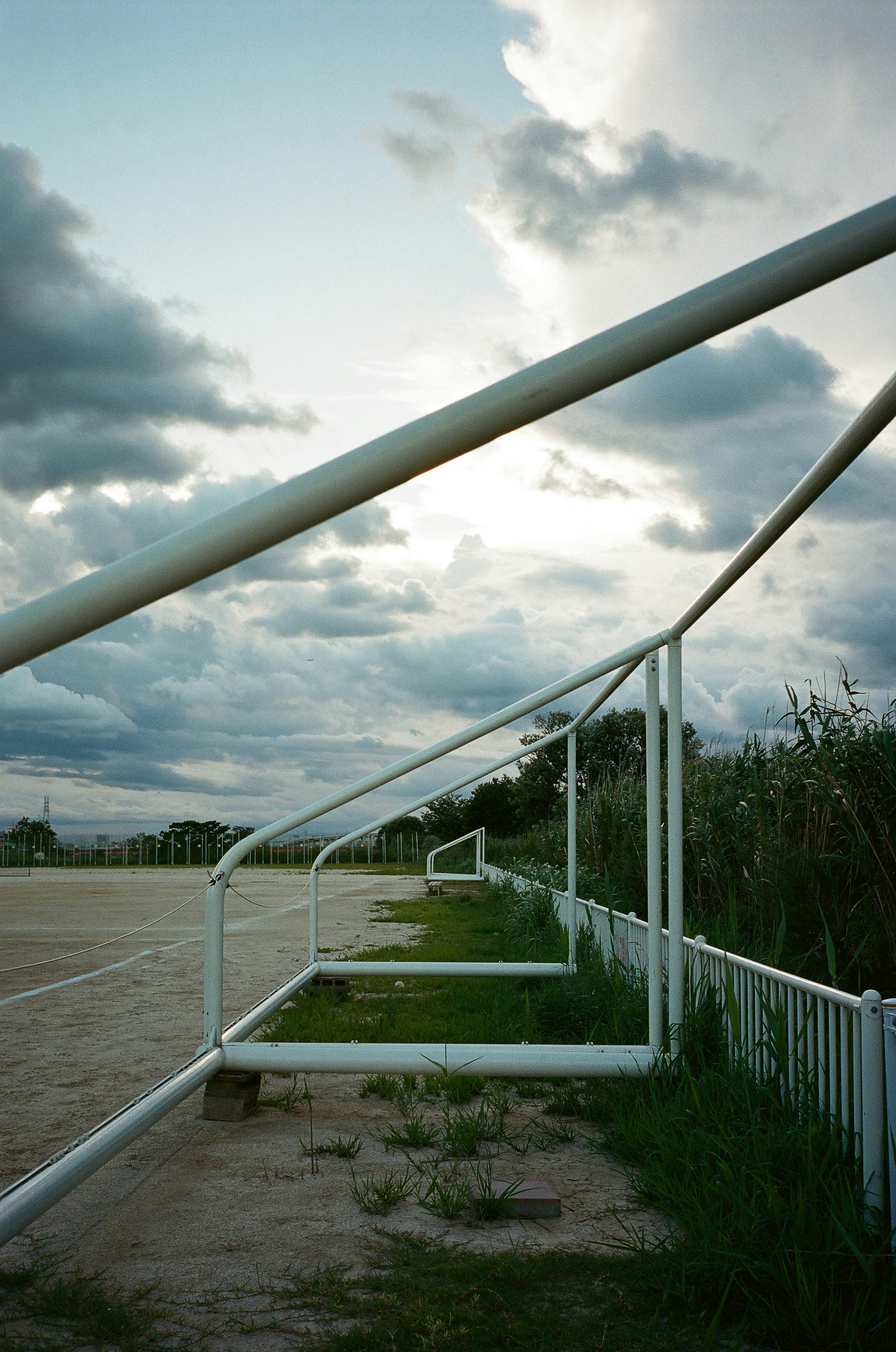 White soccer goal frame with a cloudy sky