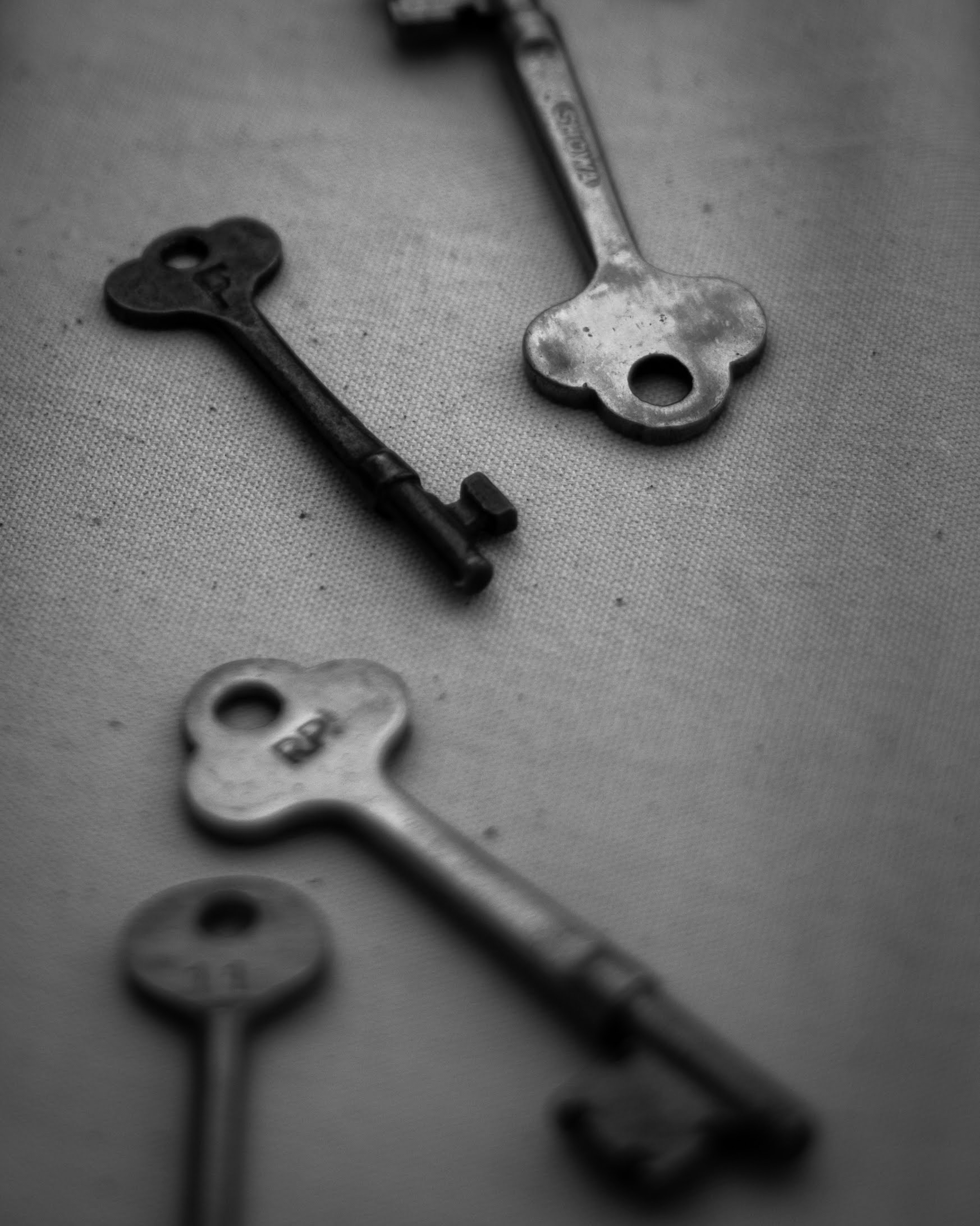 A monochrome photo of vintage keys arranged on a surface