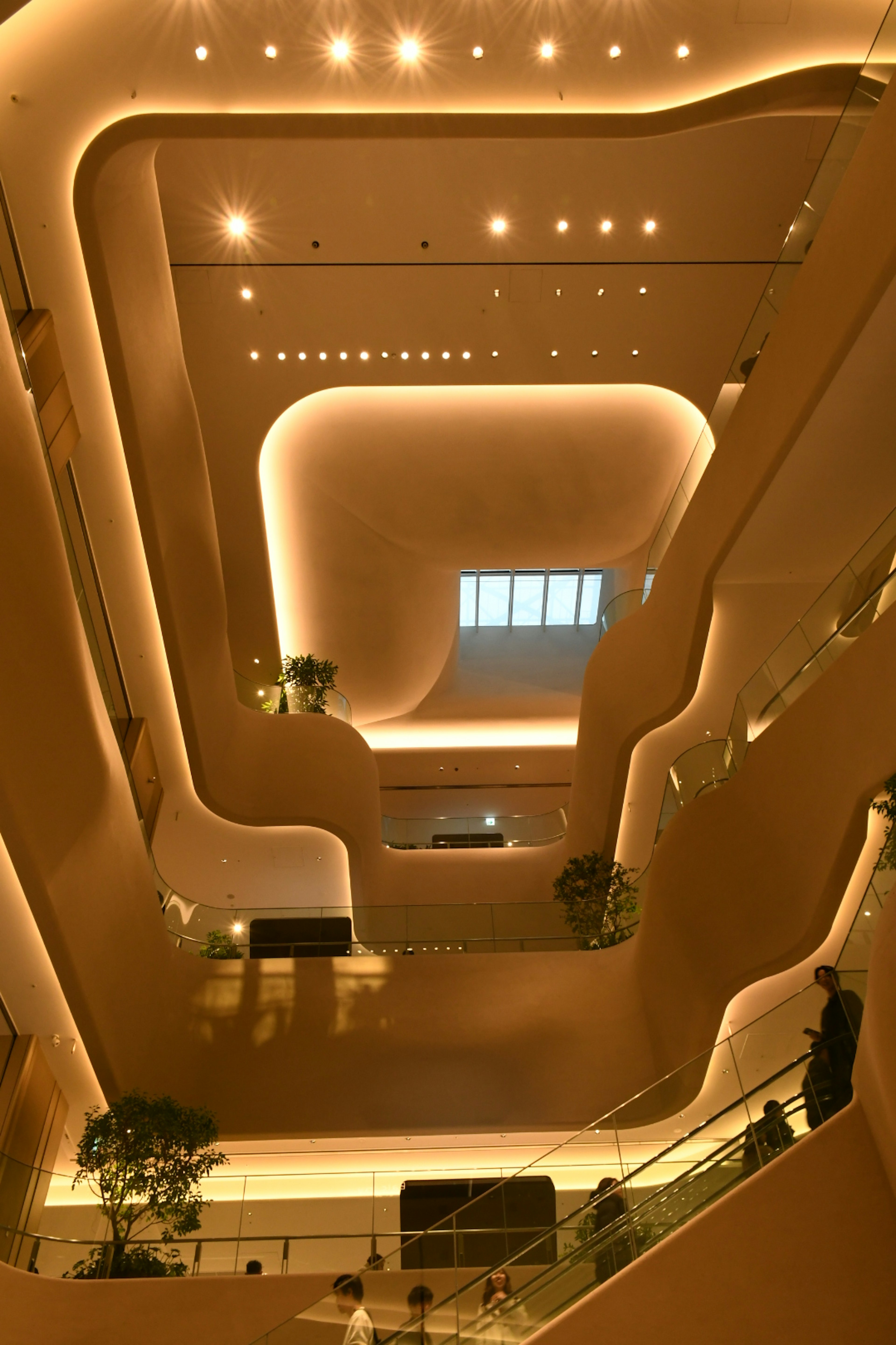 Modern architectural interior featuring smooth curved staircases and warm lighting