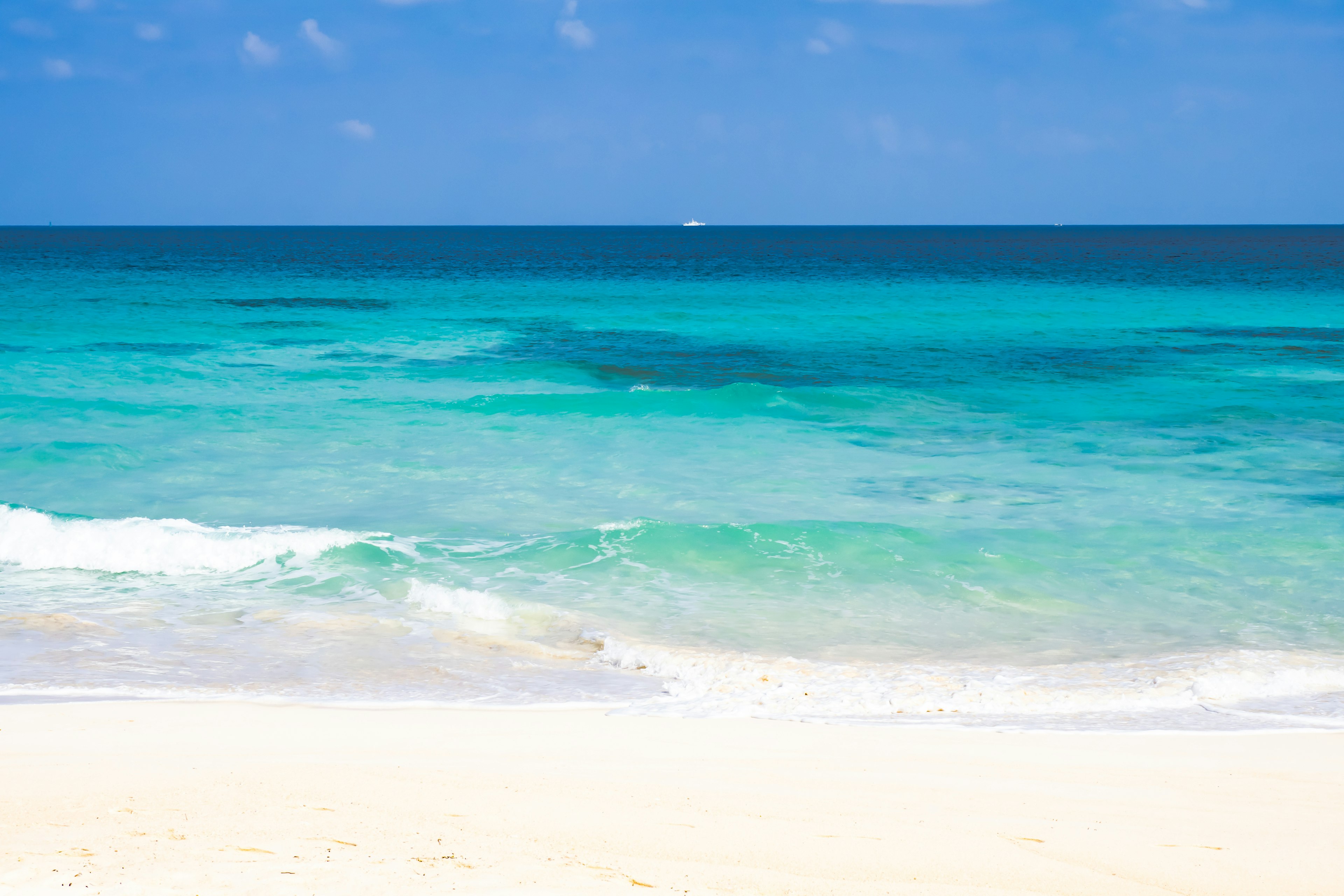 A beautiful beach scene with blue sea and white sandy shore