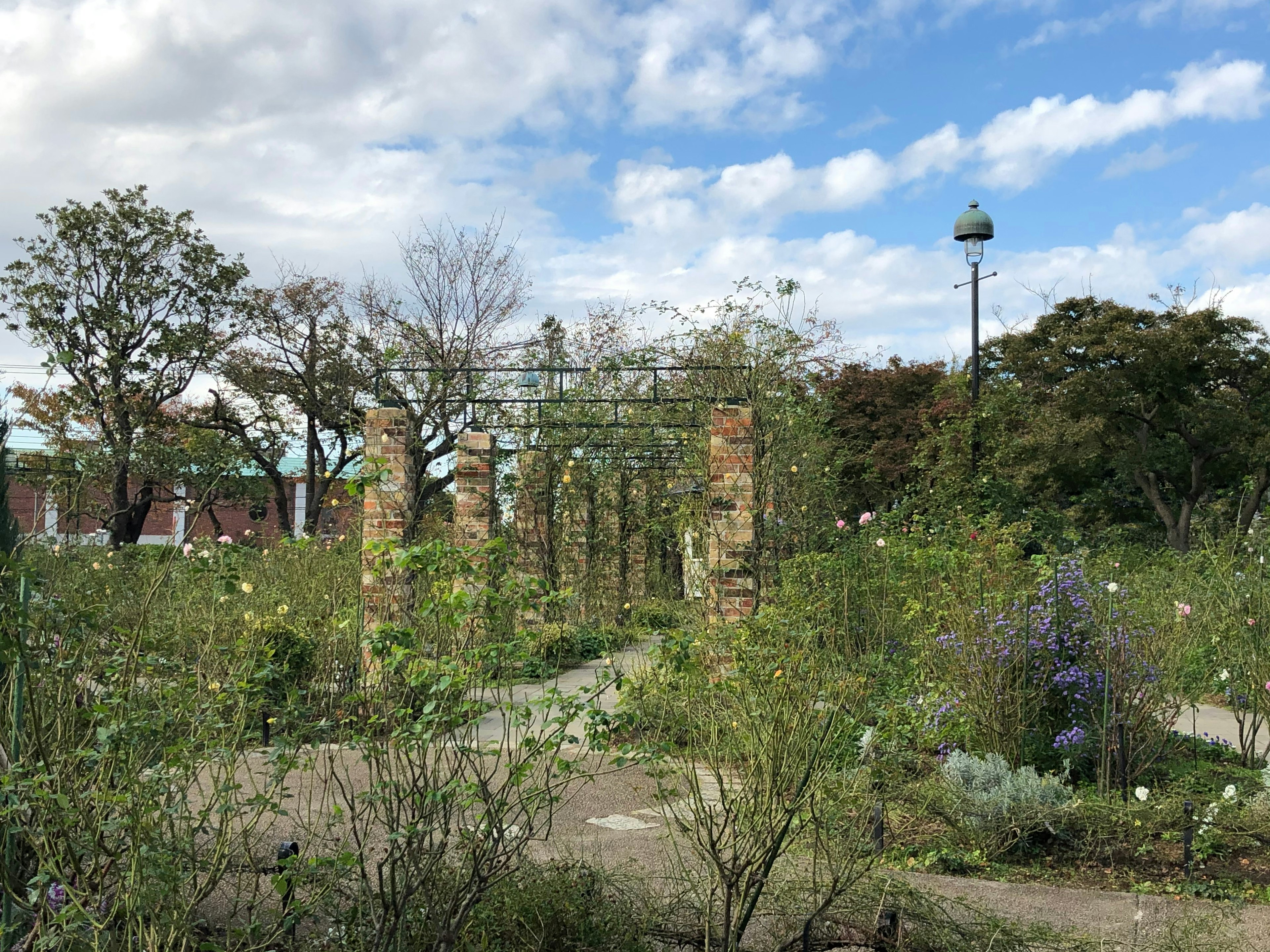 Vue panoramique d'un parc entouré de verdure avec des piliers de pierre et des fleurs