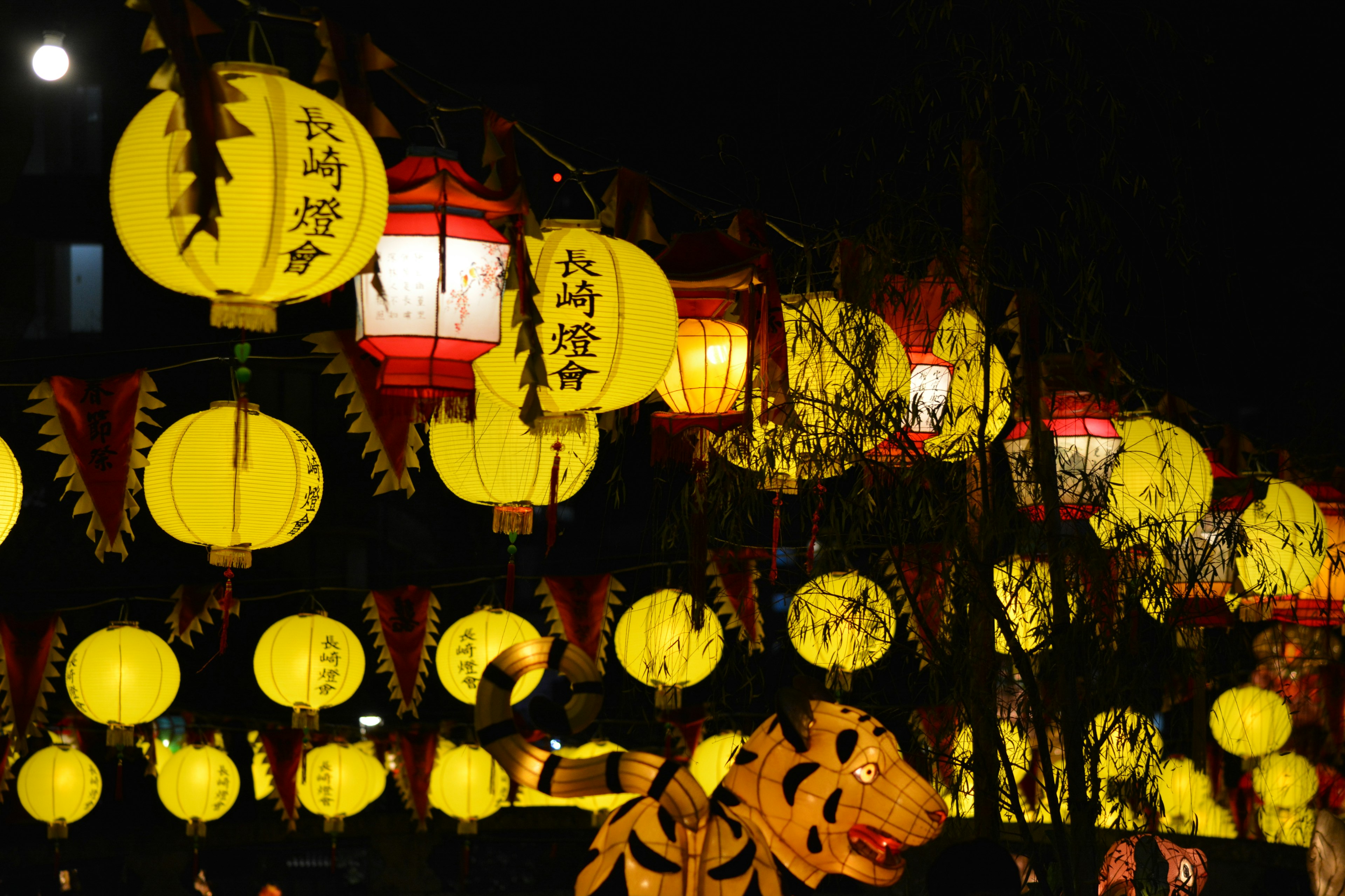 Des lanternes jaunes et une décoration de tigre lors d'un festival nocturne