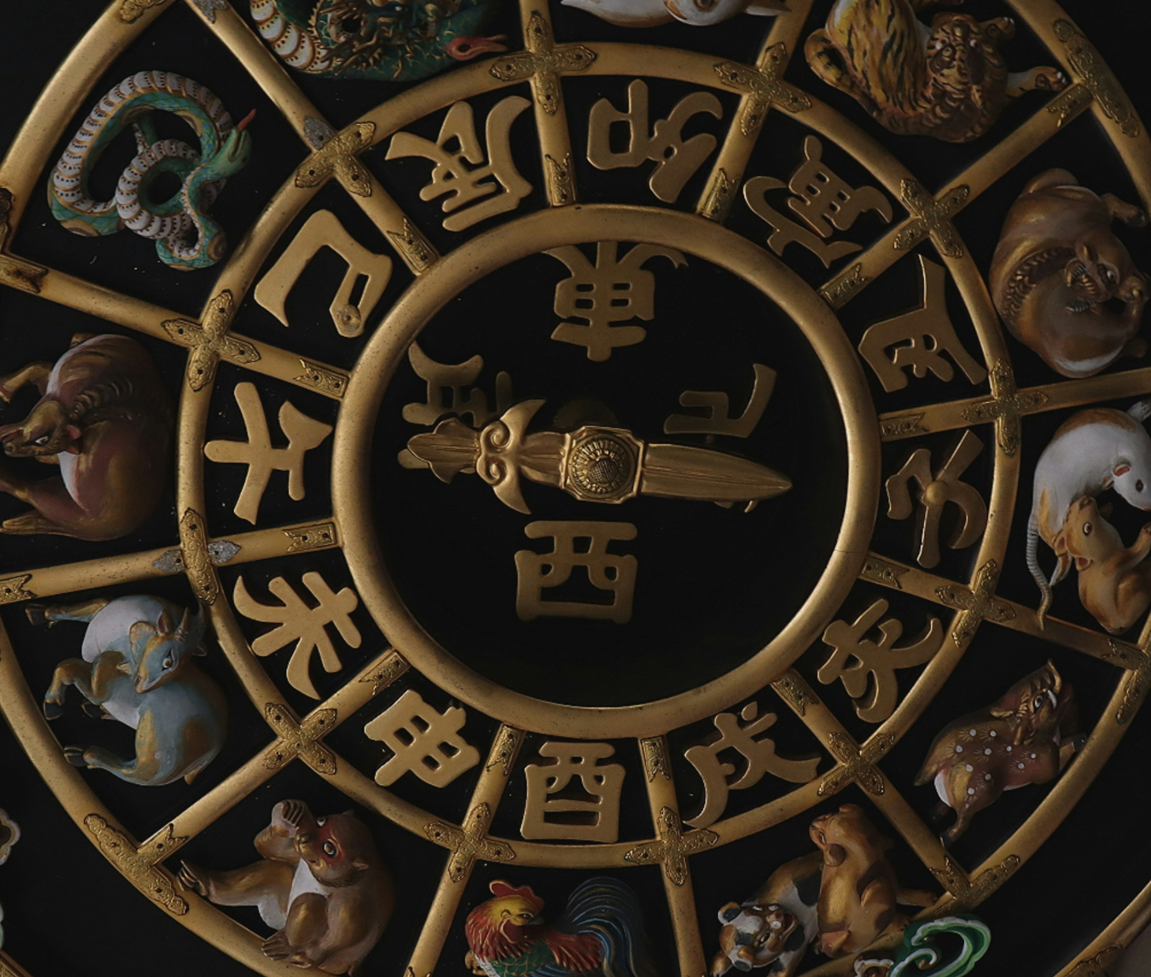 Circular decorative piece featuring the twelve zodiac animals with a compass at the center