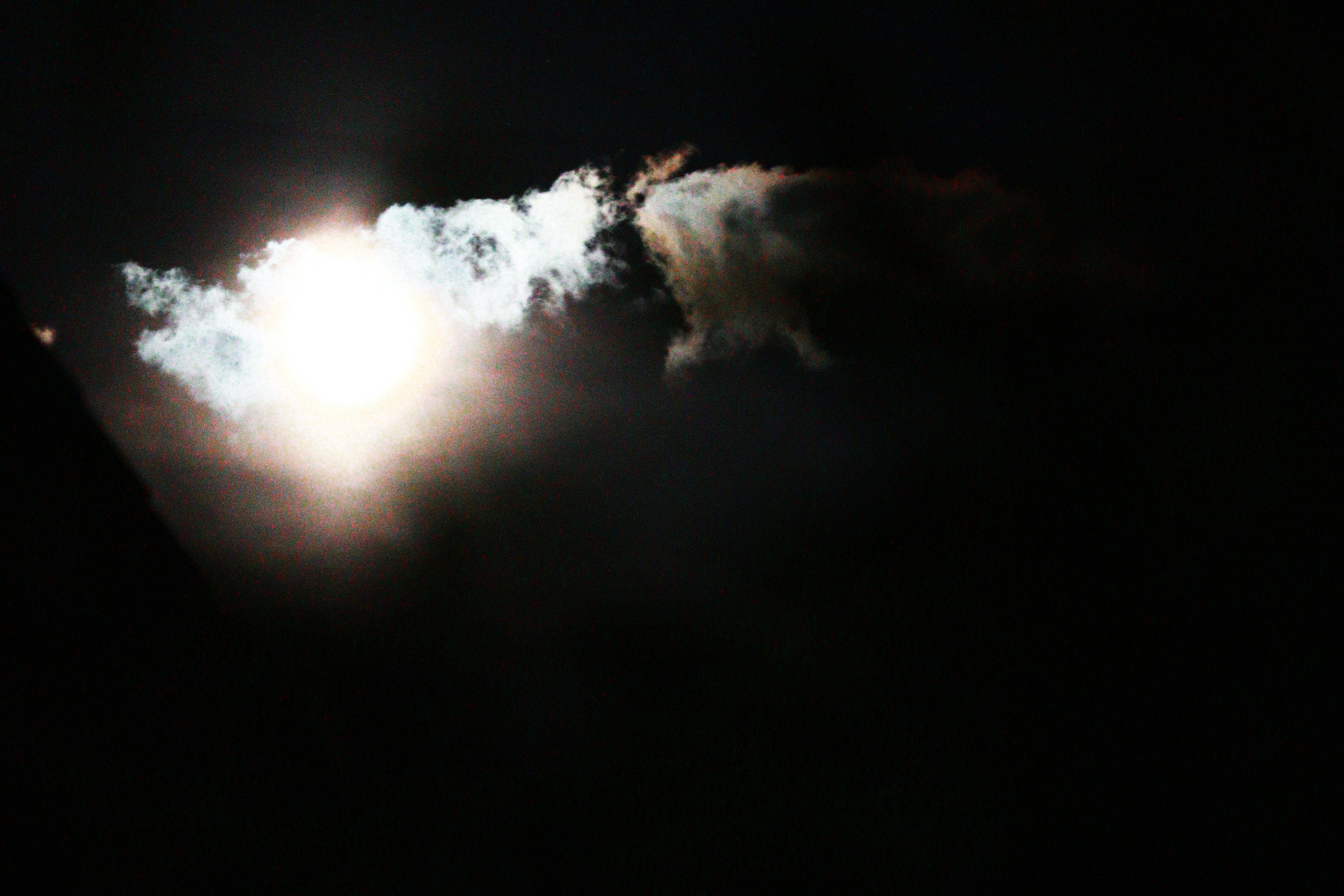 Luz brillante rodeada de nubes contra un fondo oscuro