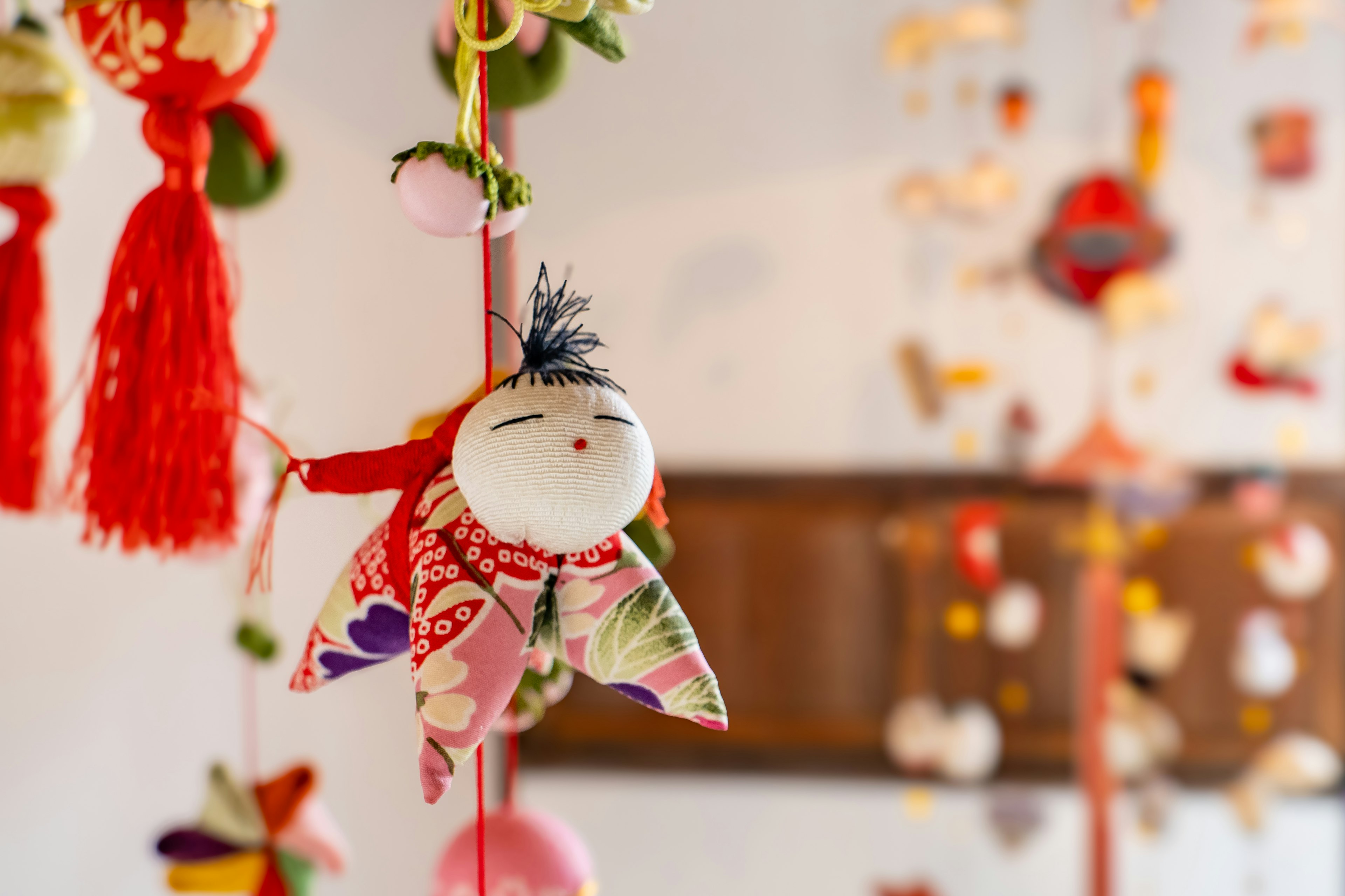 Traditional Japanese doll hanging among colorful decorations