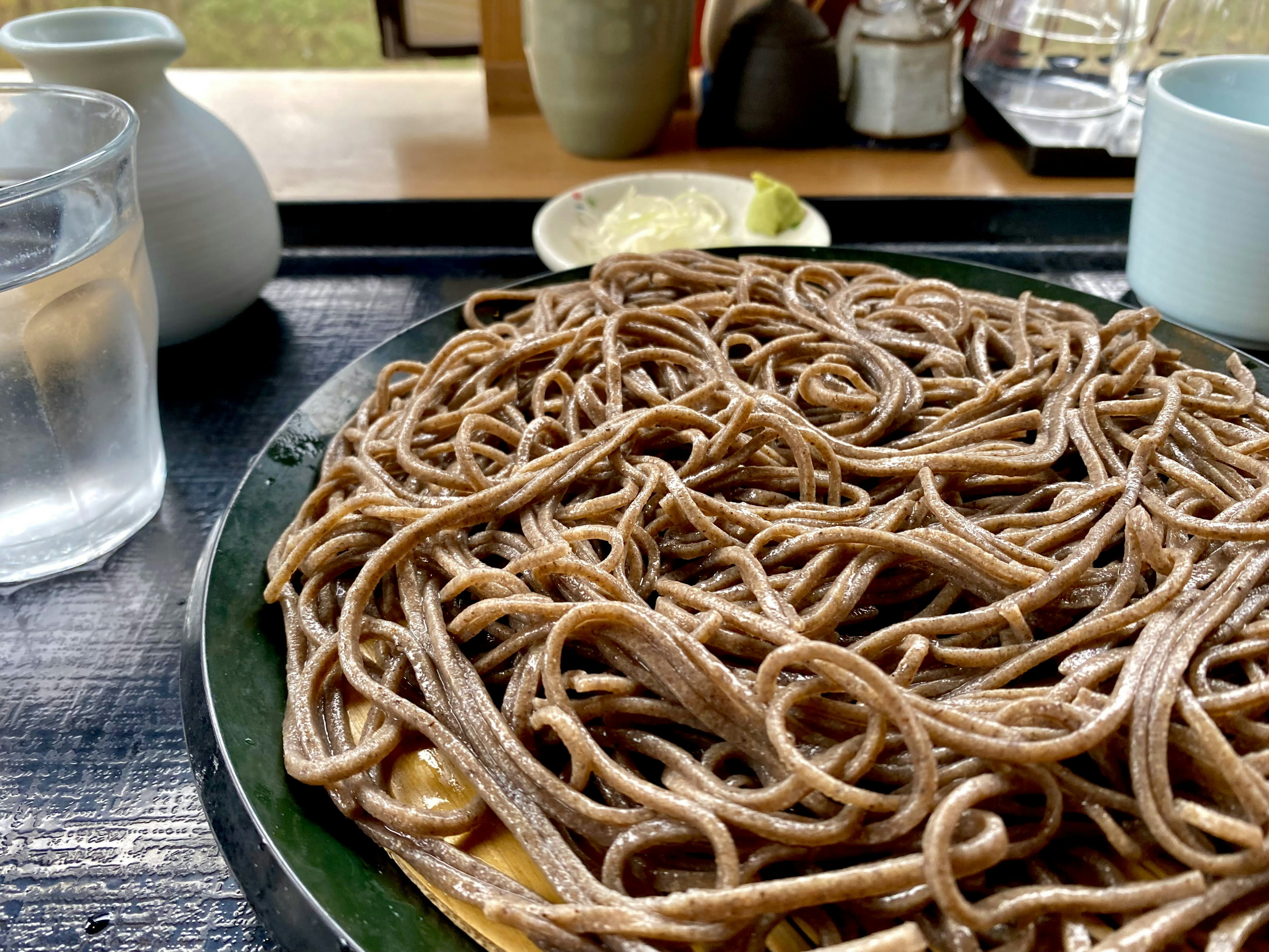 Plato de fideos soba con vasos de agua en la mesa