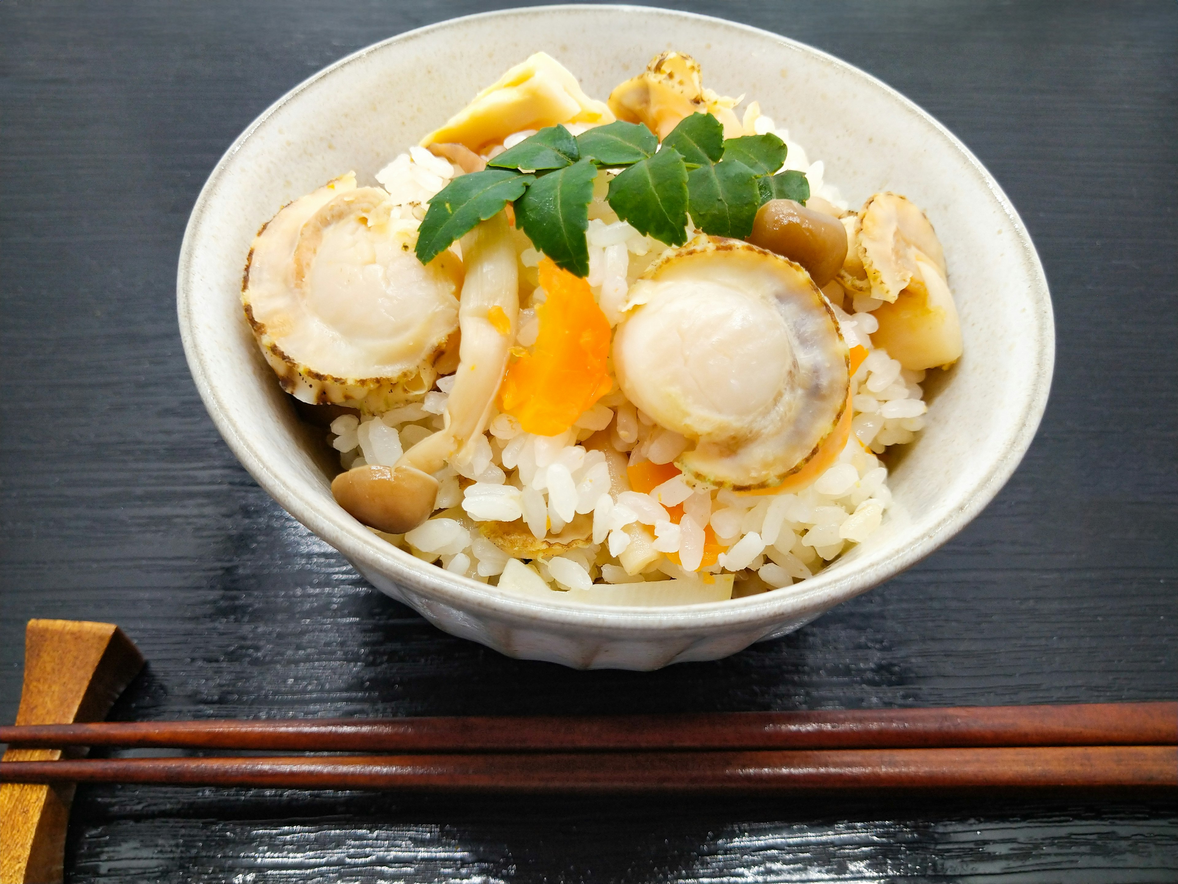 Bowl of rice topped with shellfish and vegetables