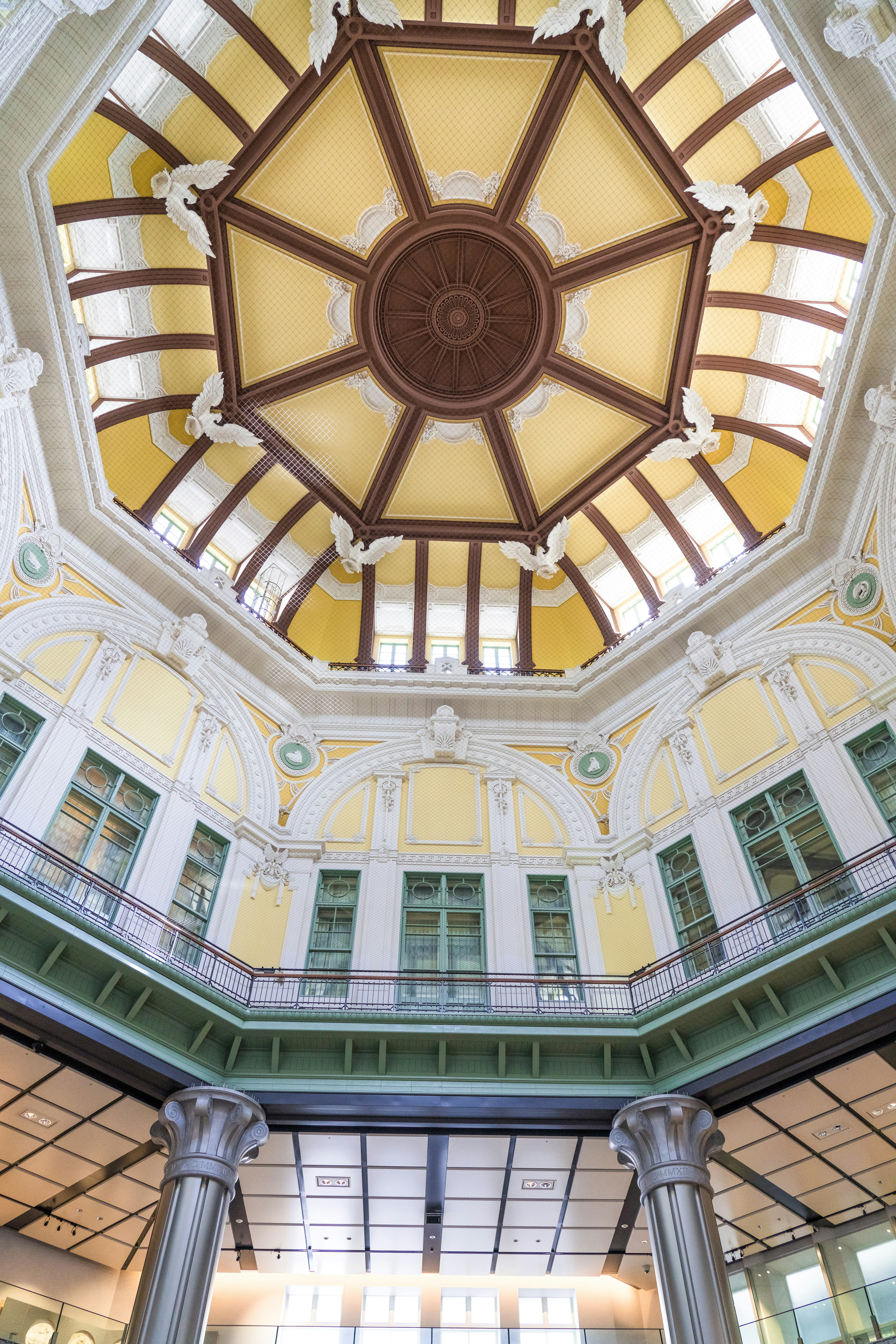 Pemandangan interior gedung dengan langit-langit kubah yang indah dinding warna krim dan balok kayu