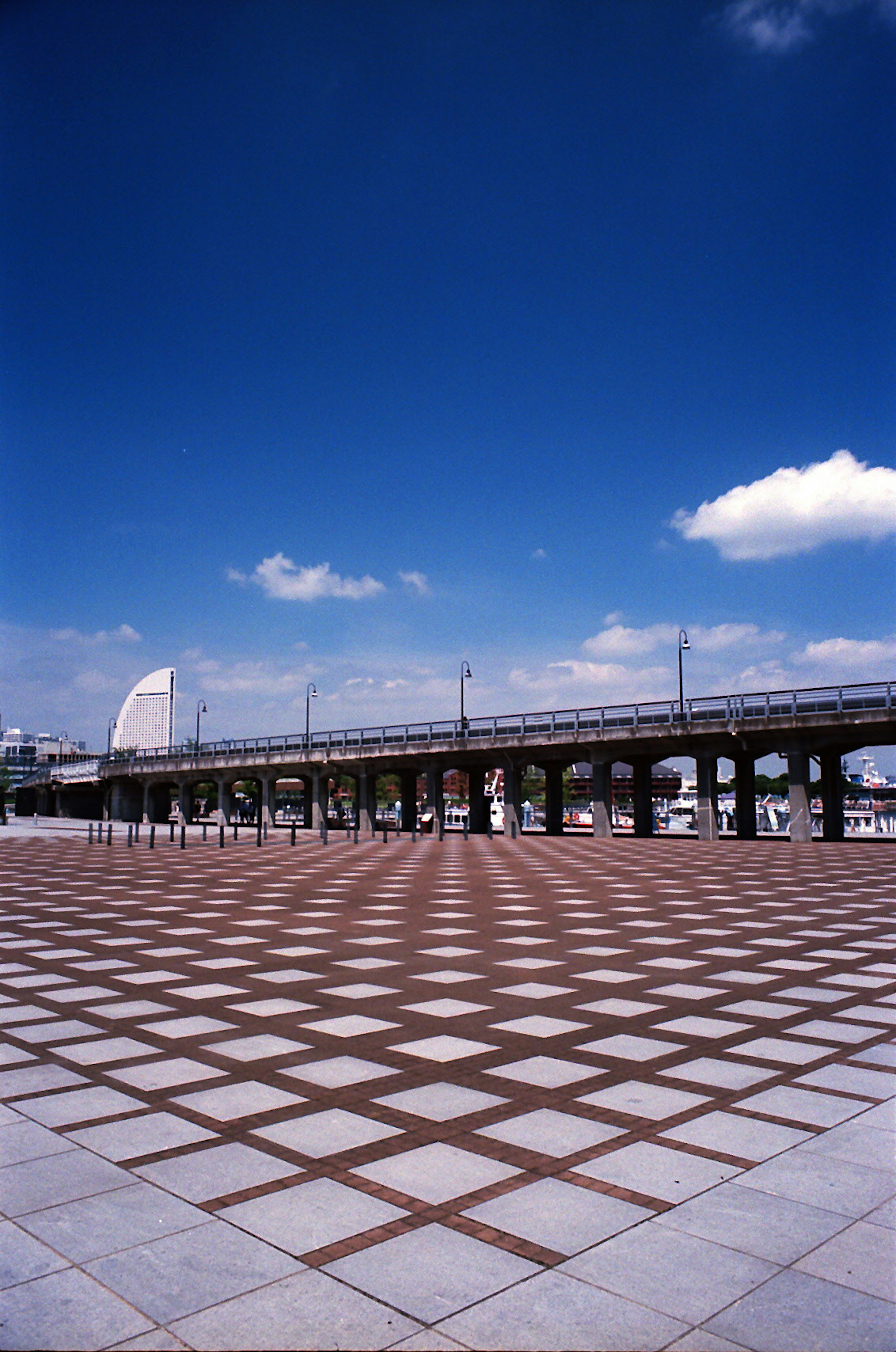 Geometrisch gemusterte Fliesen mit einer Eisenbahnbrücke unter einem blauen Himmel