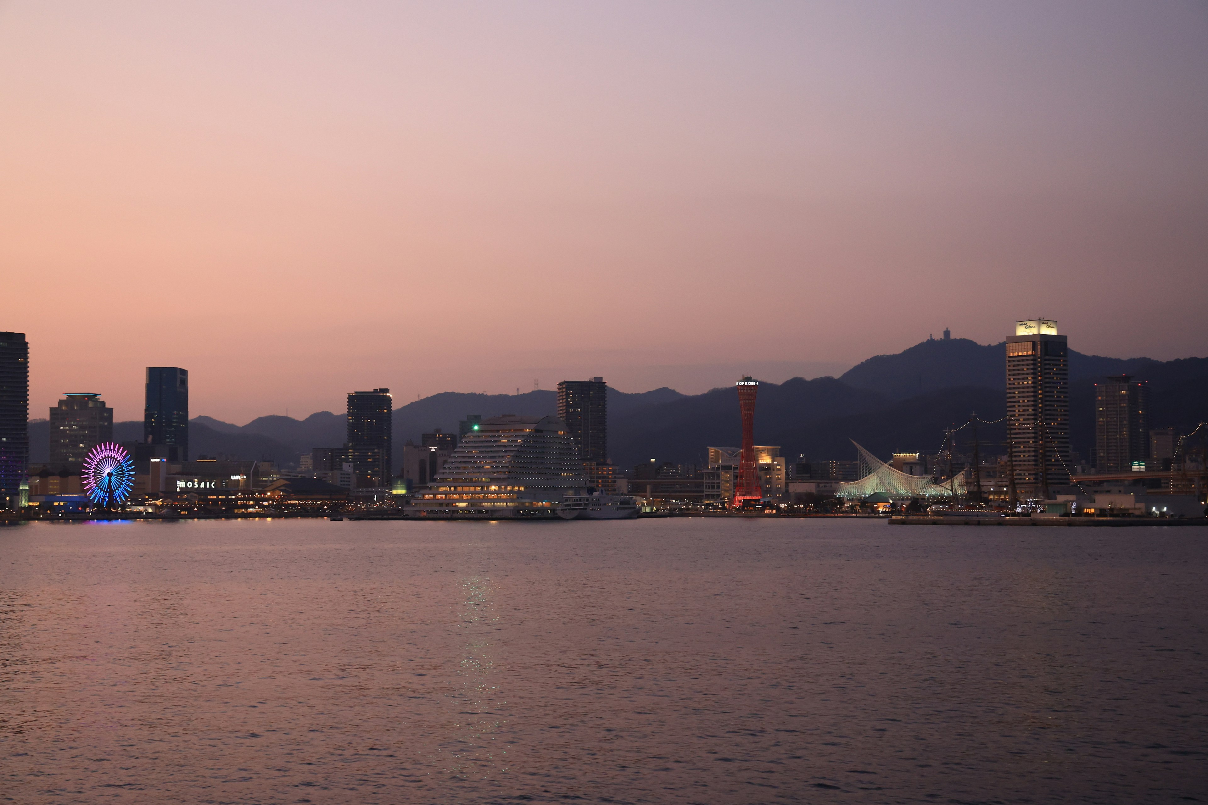 夕暮れ時の都市風景と山の背景