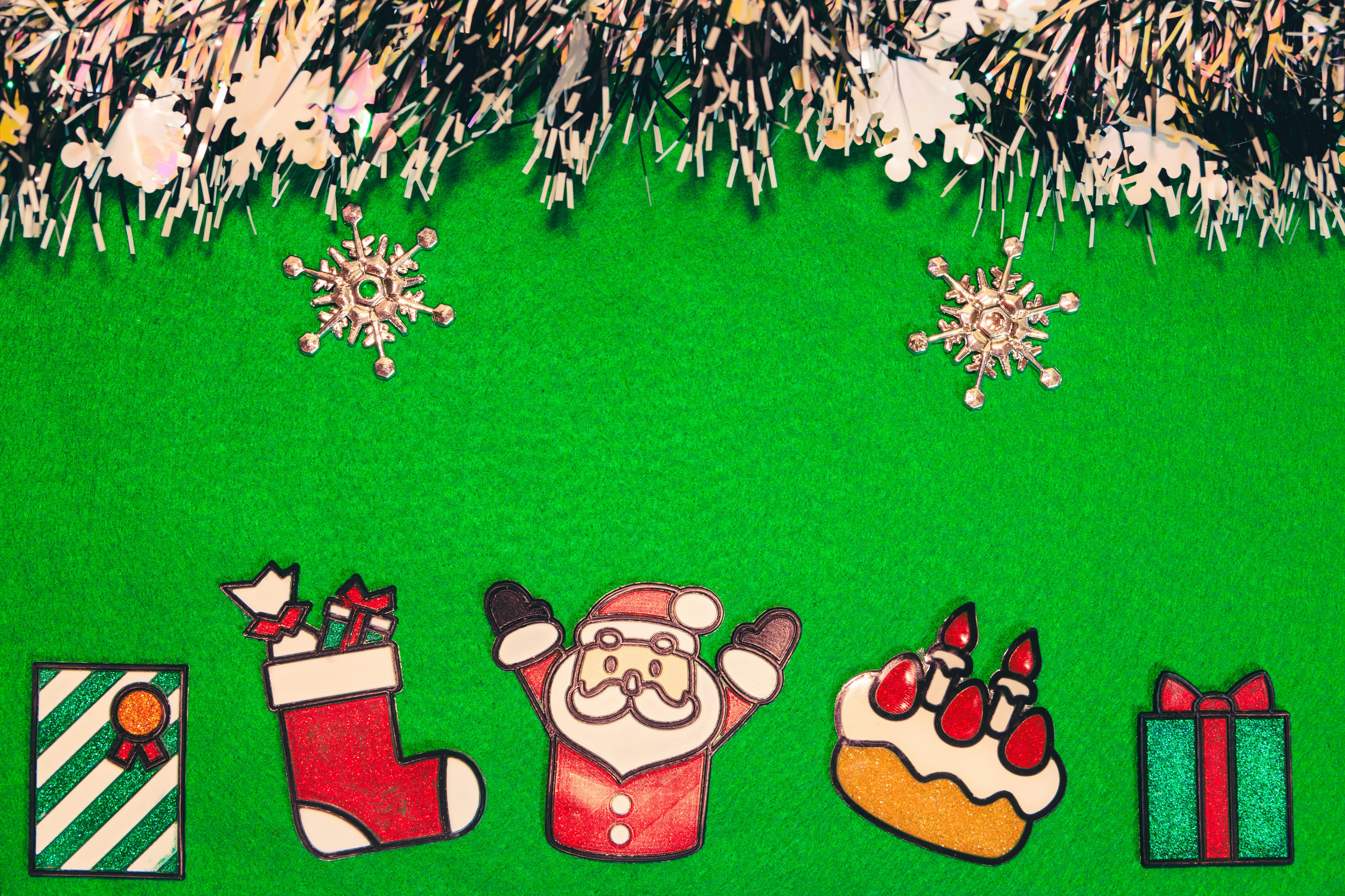 Colorful Christmas decorations featuring Santa Claus gifts and a cake on a green background