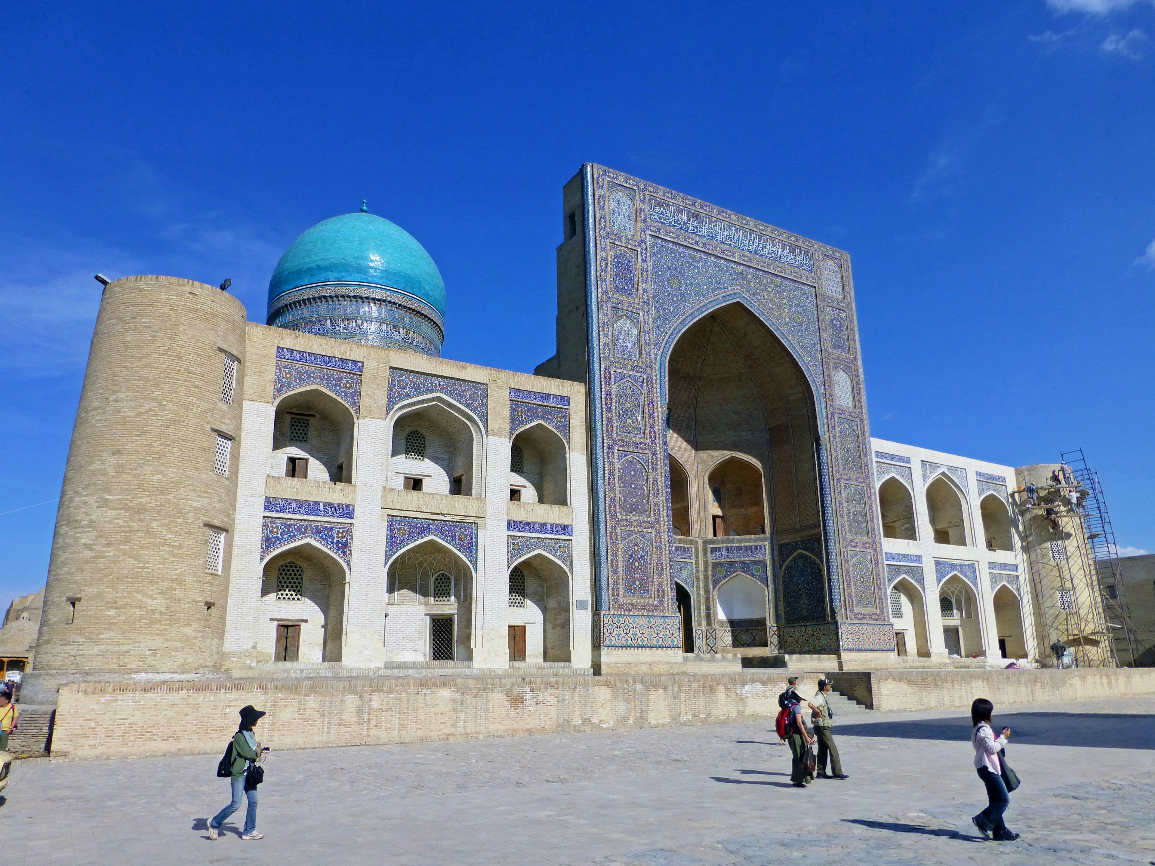 Scenic view of a building with a blue dome and intricate tile work in a plaza