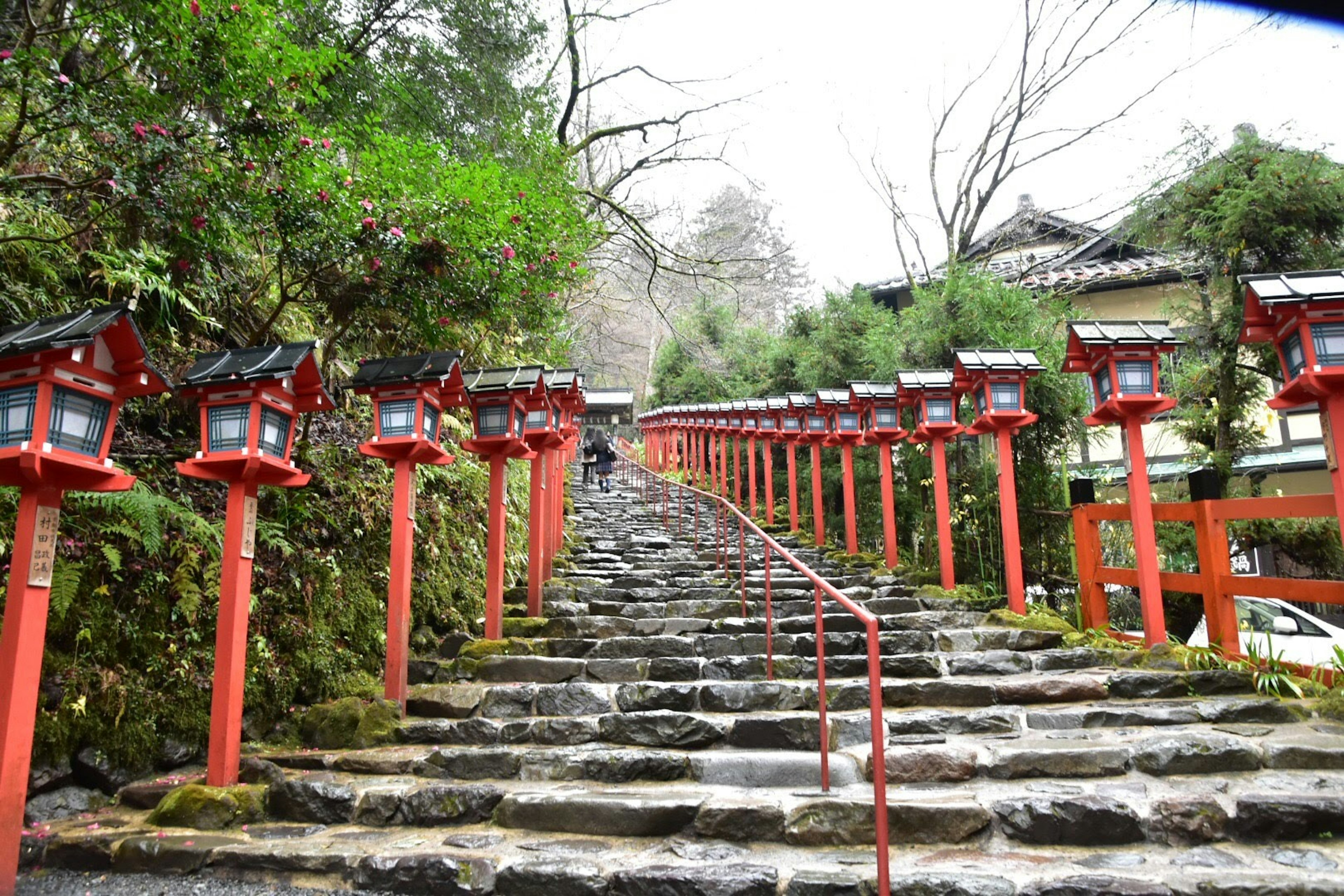 Stairway lined with red lanterns leading up a stone path