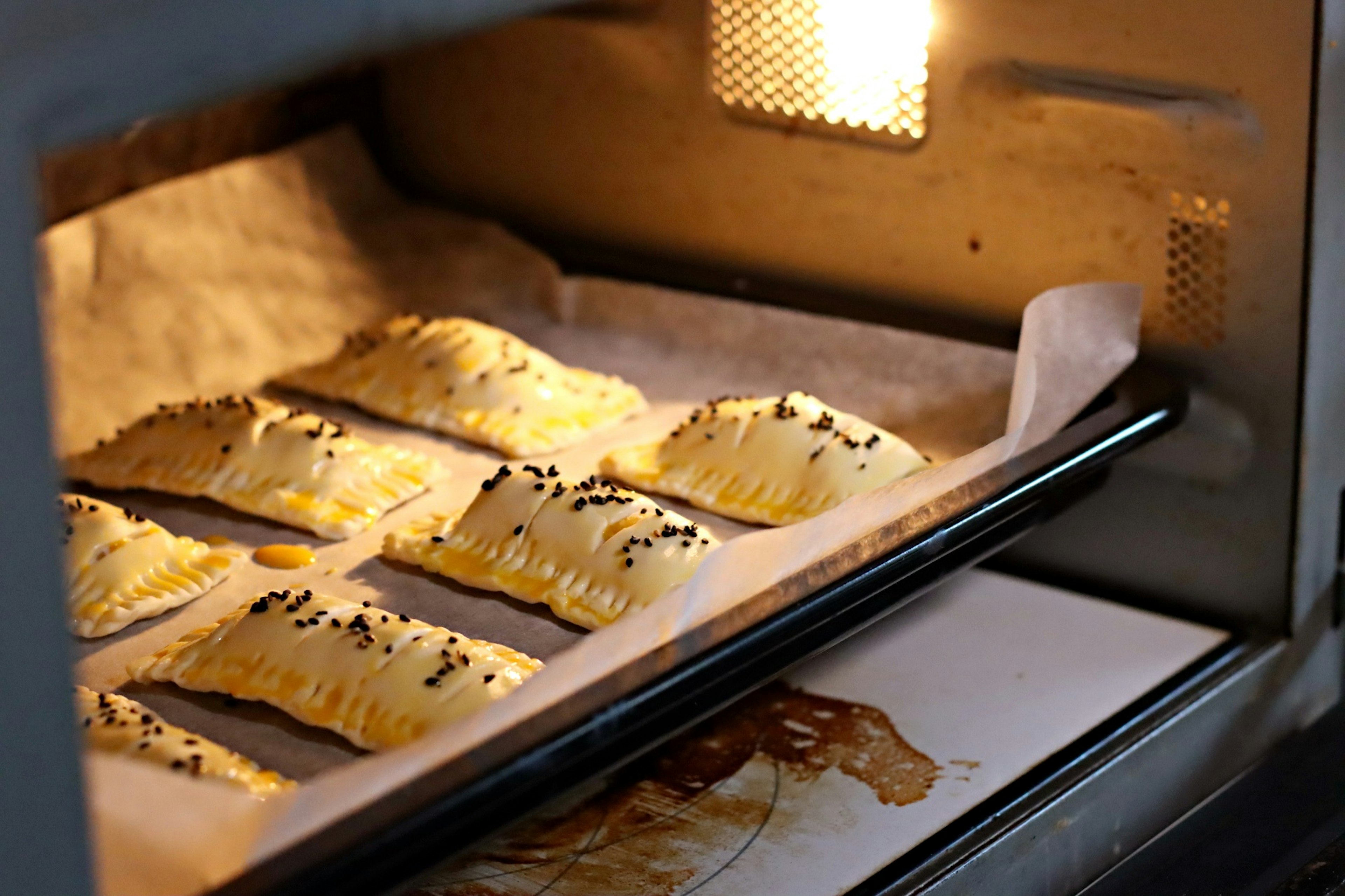 Freshly baked pastries arranged in an oven with warm light