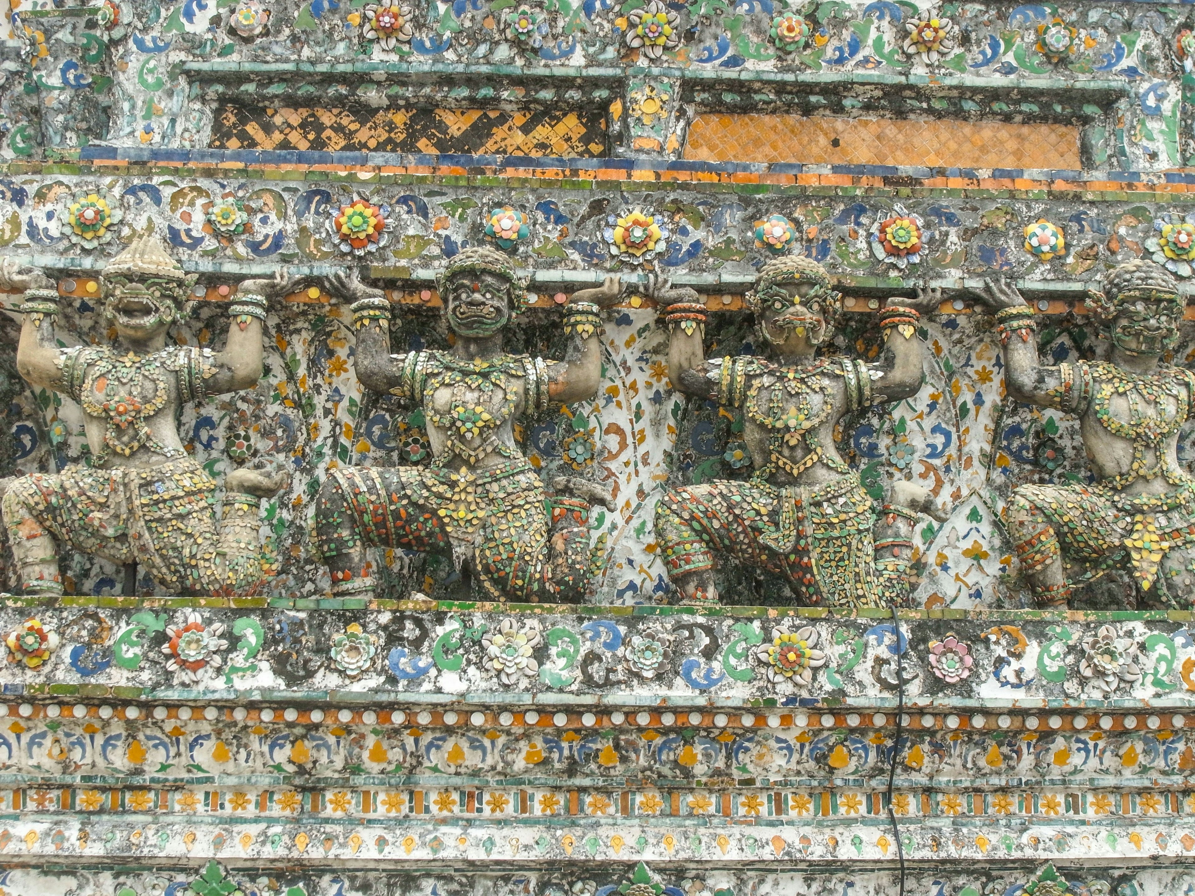 Mythical characters adorned on a temple wall with intricate decorations