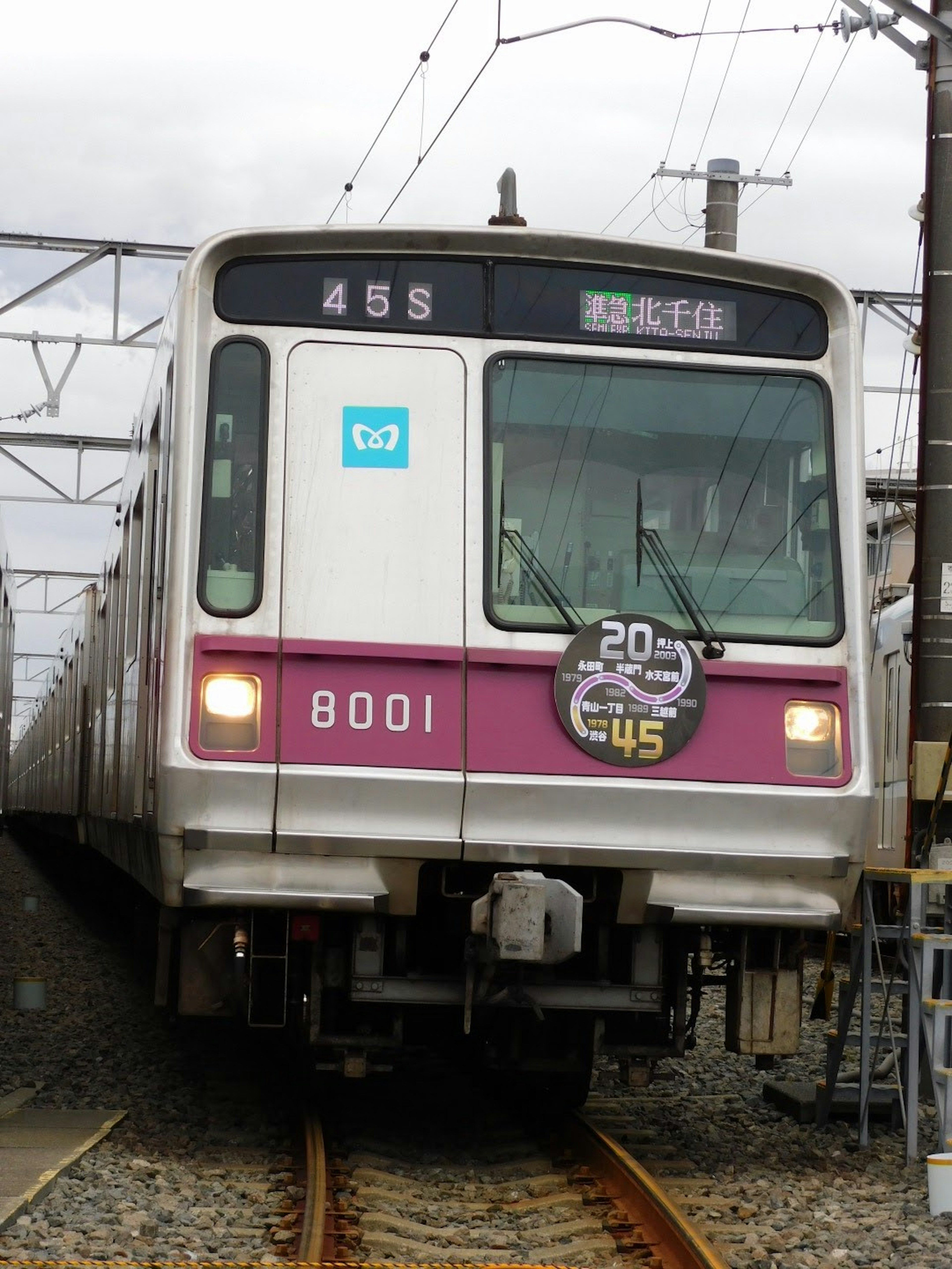 Train number 8001 on tracks with a purple and white design