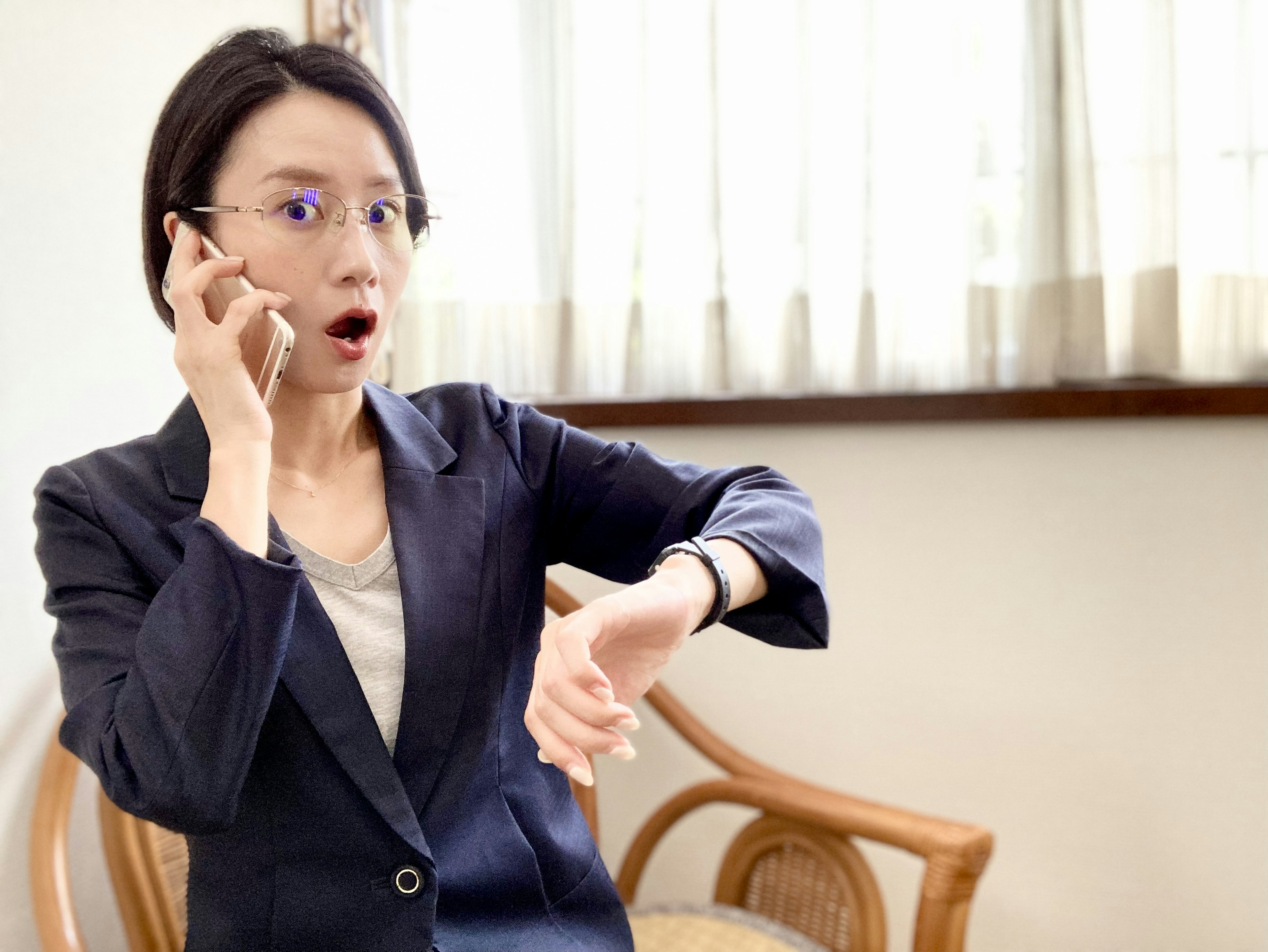 Eine überraschte Frau, die während eines Telefonats auf ihre Uhr schaut