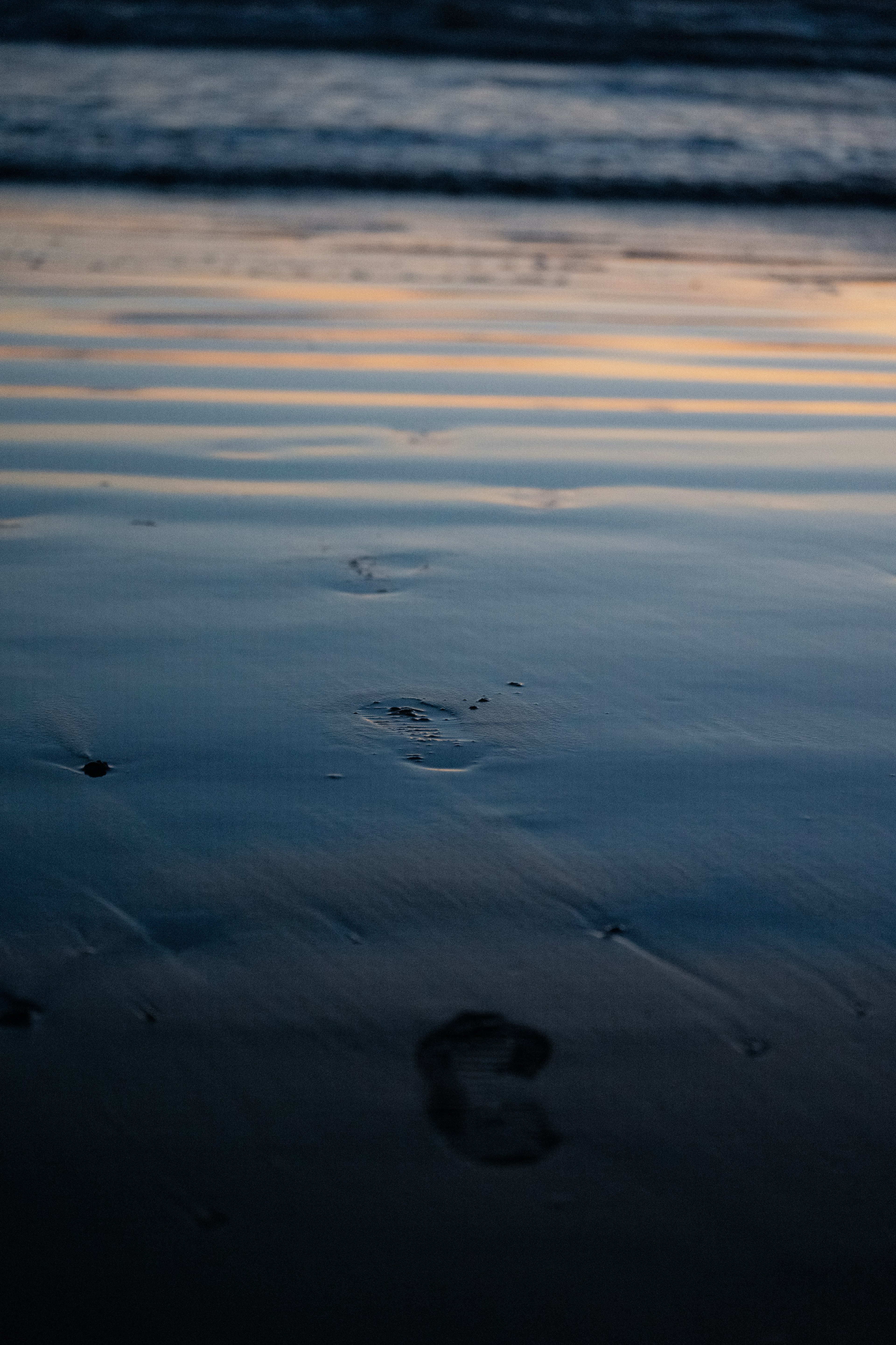 Gros plan de traces de pas sur une plage de sable ondulante