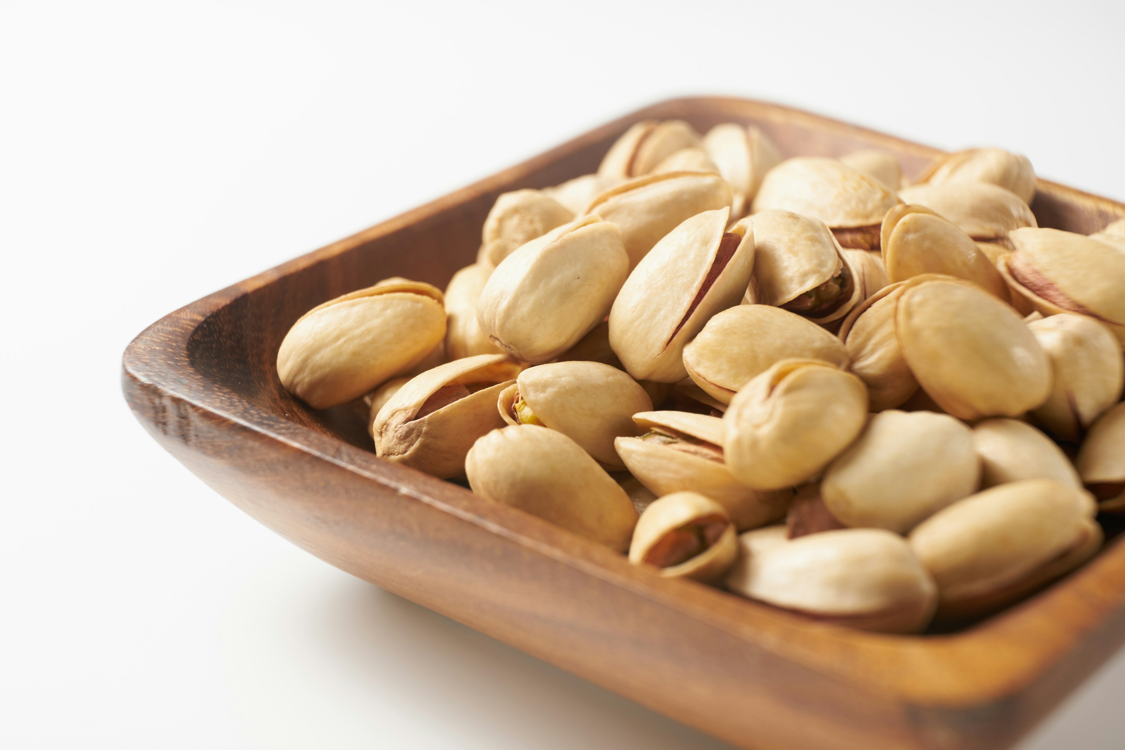 Pistachio nuts in a wooden bowl