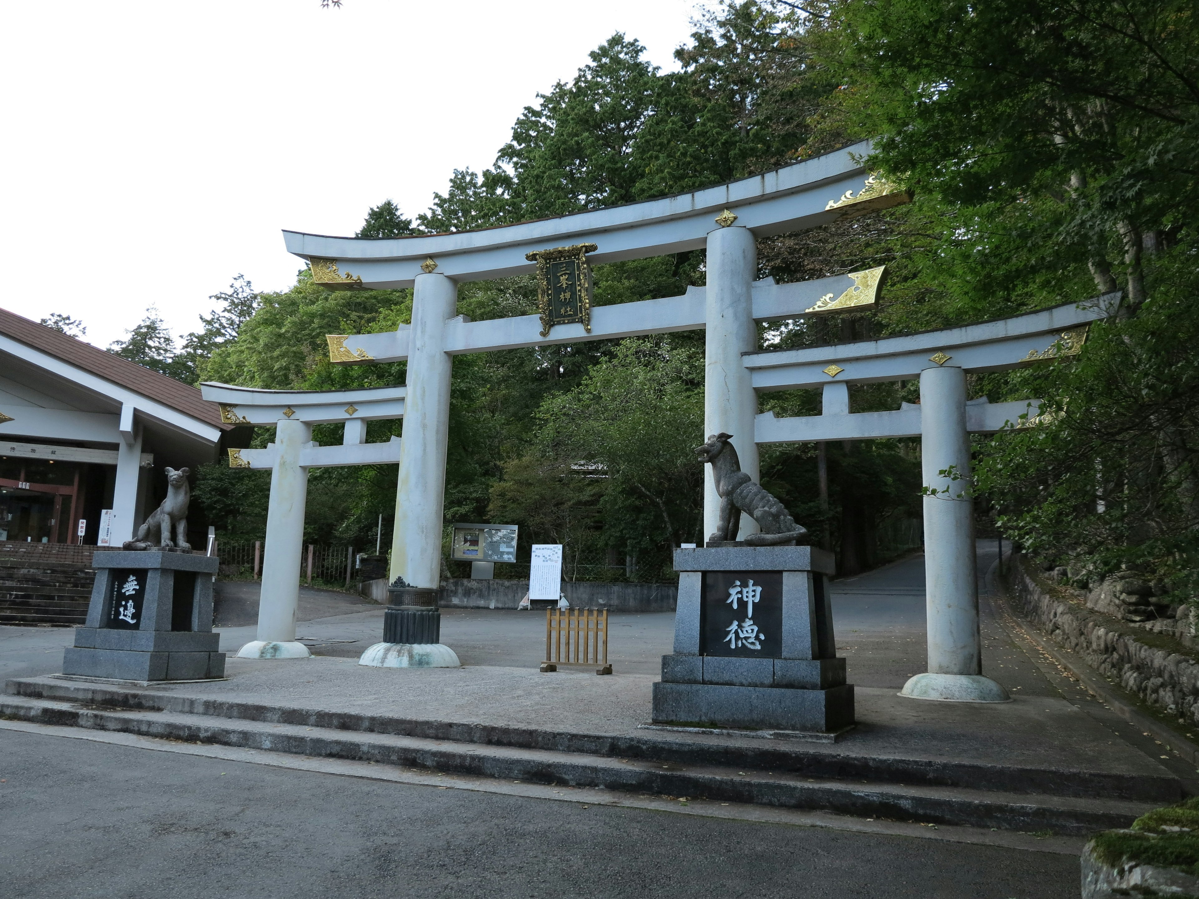 Entrée d'un sanctuaire avec un torii et des komainu en pierre